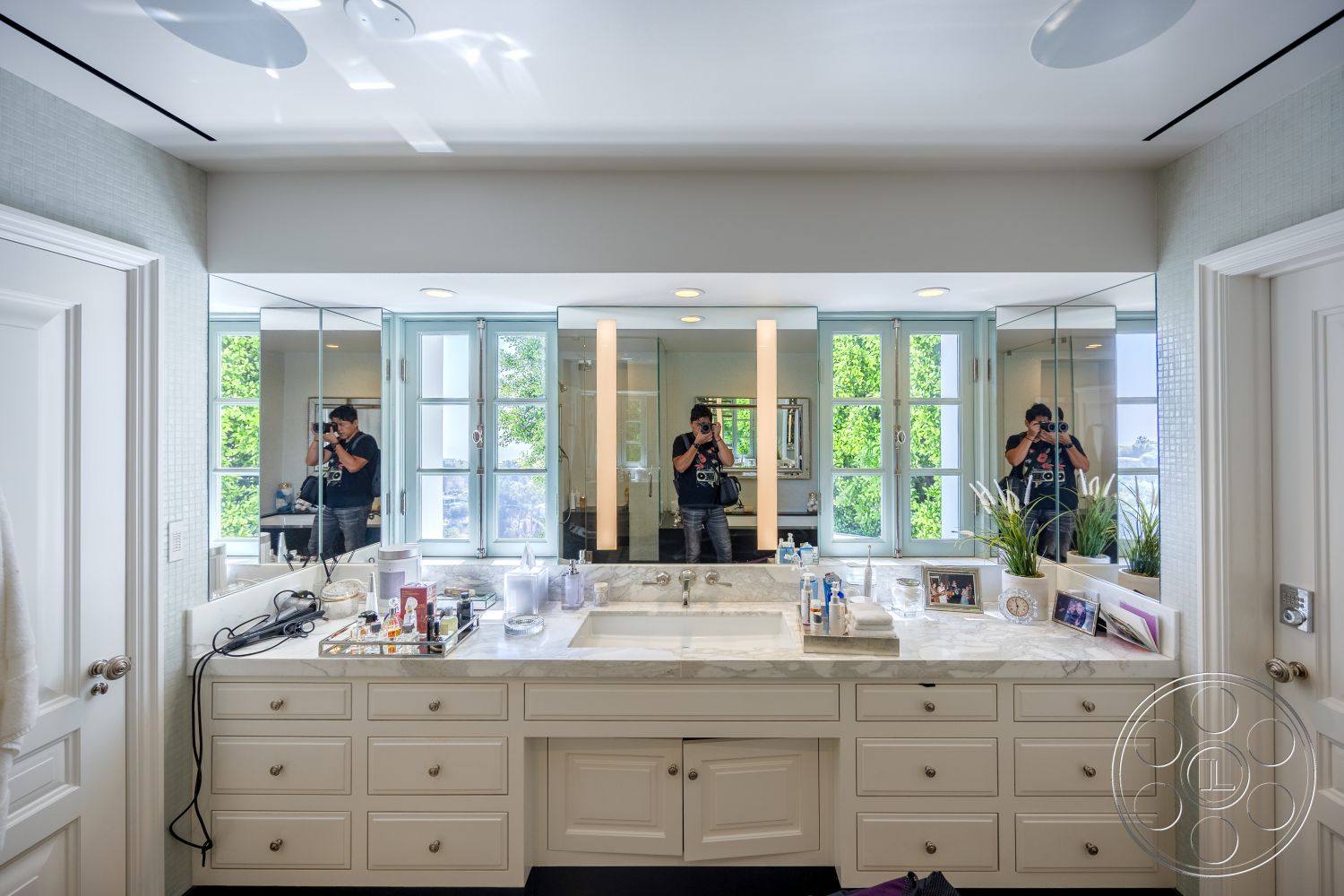 Spanish 168 - neutral color palette, bright natural light, modern lighting fixtures, double sink vanity, open plan layout, glass shower doors, chrome faucet fixtures, marble bathroom countertops, white painted cabinetry, tile bathroom flooring, mirrored wall treatment, luxurious spa-like bathroom, exterior view from windows, urban bathroom setting