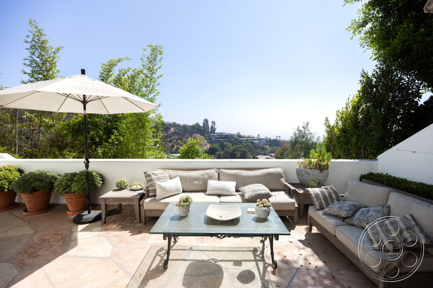 Spanish 168 - city skyline view, decorative potted plants, wooden outdoor furniture, minimalist design aesthetic, exterior stone patio flooring, sunlit outdoor area, lush greenery landscape, modern outdoor living space, hexagon-shaped stone tiles, contemporary outdoor coffee table, white canvas patio umbrella, beach house patio setting, textured white wall, comfortable cushioned seating, ceramic plant pots