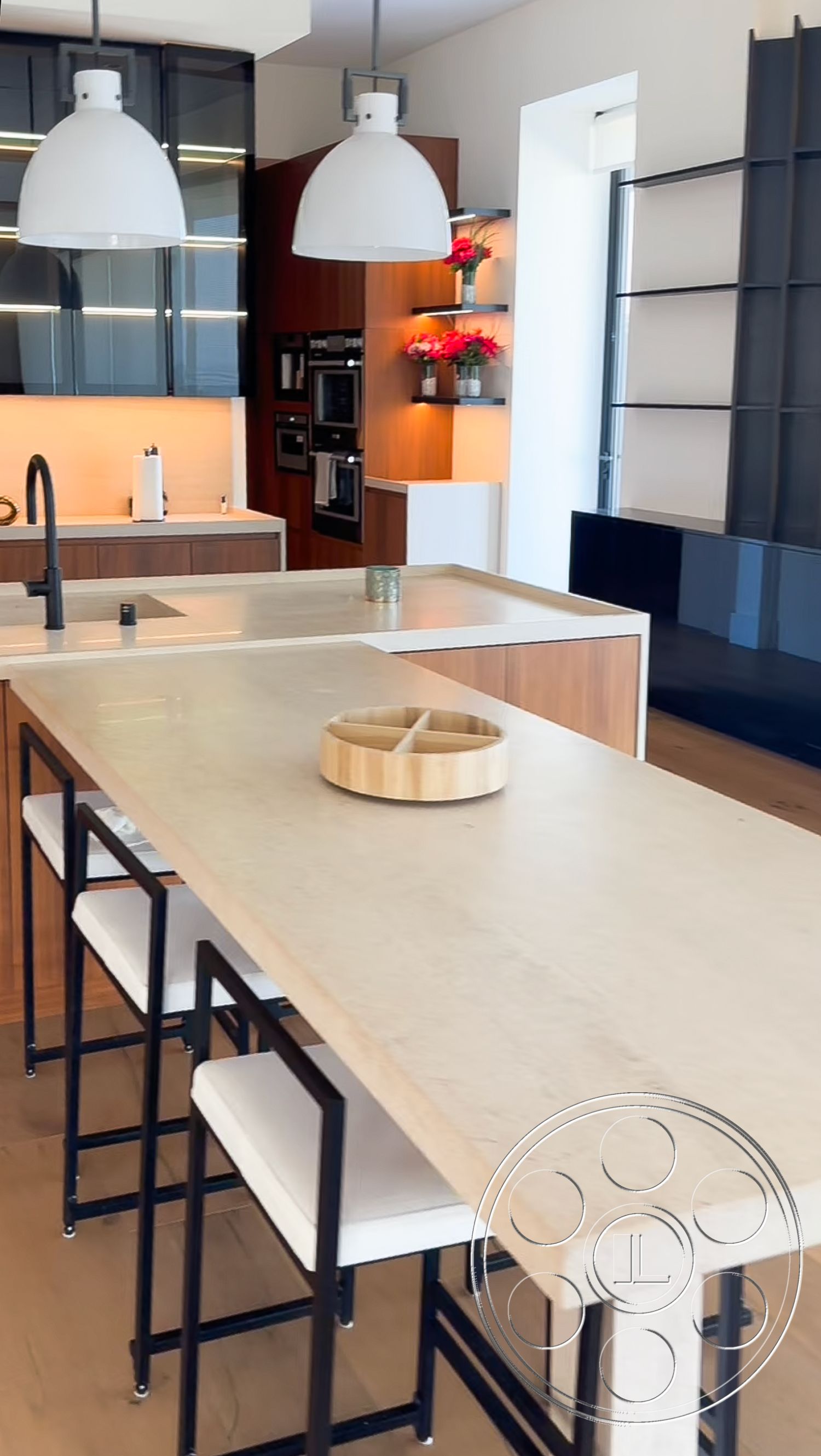 Modern 481 - kitchen, light hardwood flooring, modern pendant lighting fixtures, built-in stainless steel appliances, interior kitchen with concrete countertop, black cabinetry with glass fronts, wooden shelves with decorative flowers, bar-style seating with metal frame stools, open concept design with natural light, minimalist style kitchen island, neutral color palette with warm accents, textured wall with warm lighting, smooth surface kitchen backsplash