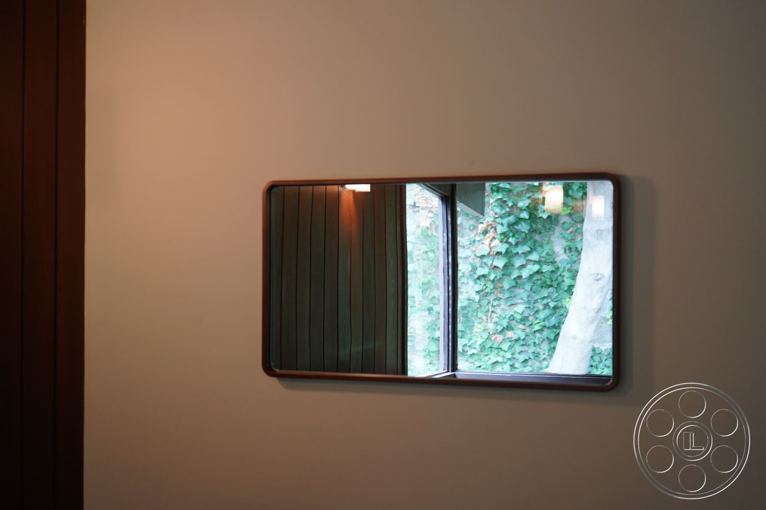 MCM 25 - minimalist decor, indoor-outdoor flow, earthy color palette, textured wall finish, contemporary design elements, interior framed mirror, interior wood paneling wall, interior window with view to greenery, natural light interior space, holistic living environment
