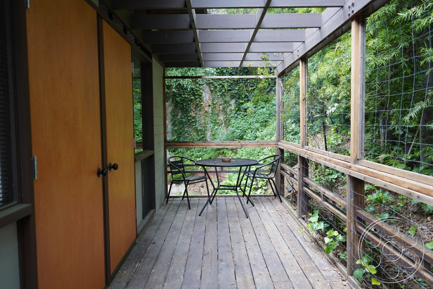 MCM 25 - natural light, outdoor seating area, surrounding greenery, exposed wood beams, metal outdoor furniture, open outdoor space, wooden railing, wooden sliding doors, wooden deck flooring, wood paneling interior, urban garden patio, glass door entrance, interior storage cabinets, rustic home design, enclosed porch
