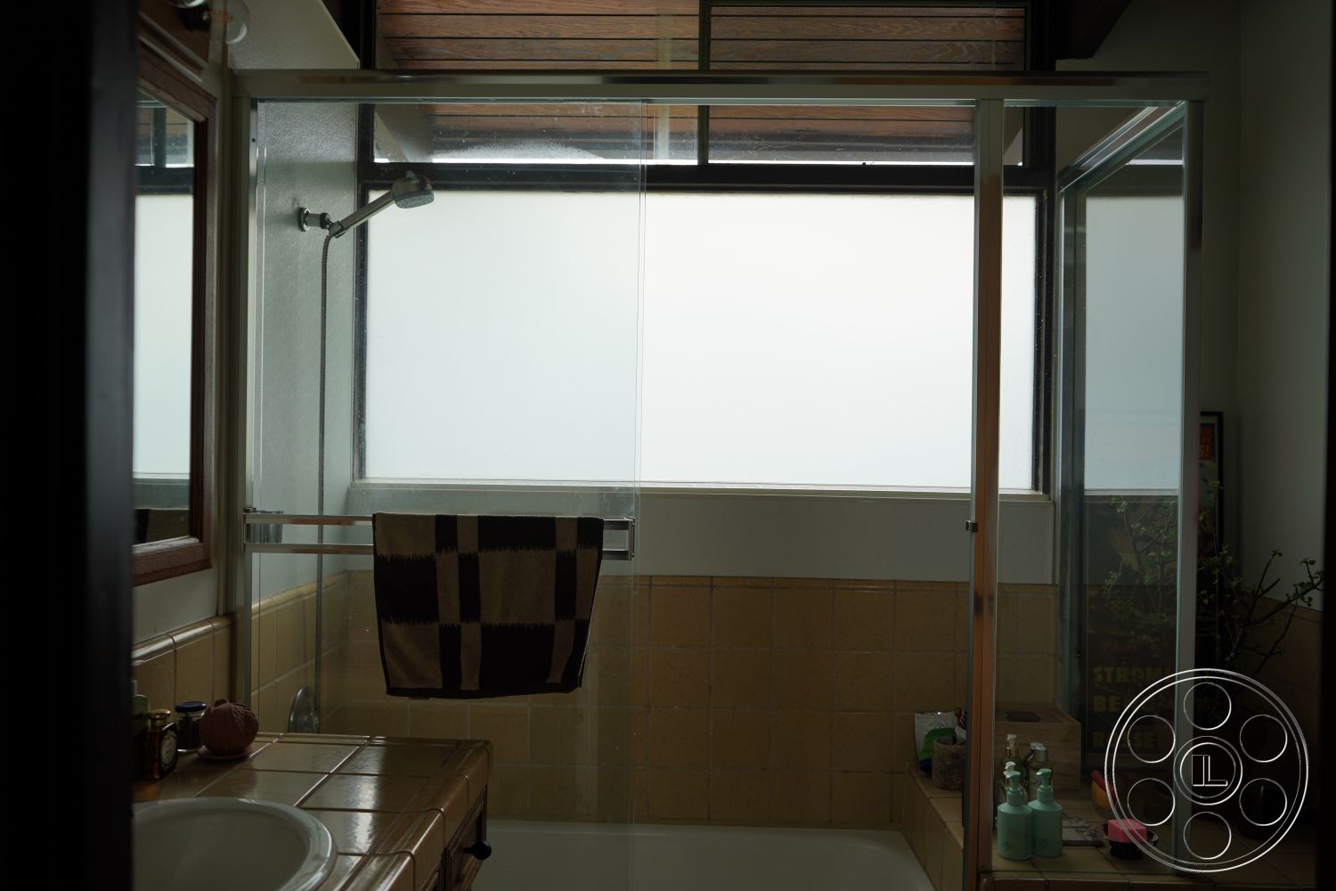 MCM 25 - neutral color palette interior, textured plaster walls interior, glass shower doors interior, tile bathroom walls interior, stainless steel shower hardware interior, wood accent window frame interior, beige tile flooring interior, modern fixtures interior, open shower design interior, minimalist bathroom design interior, natural light through frosted glass interior
