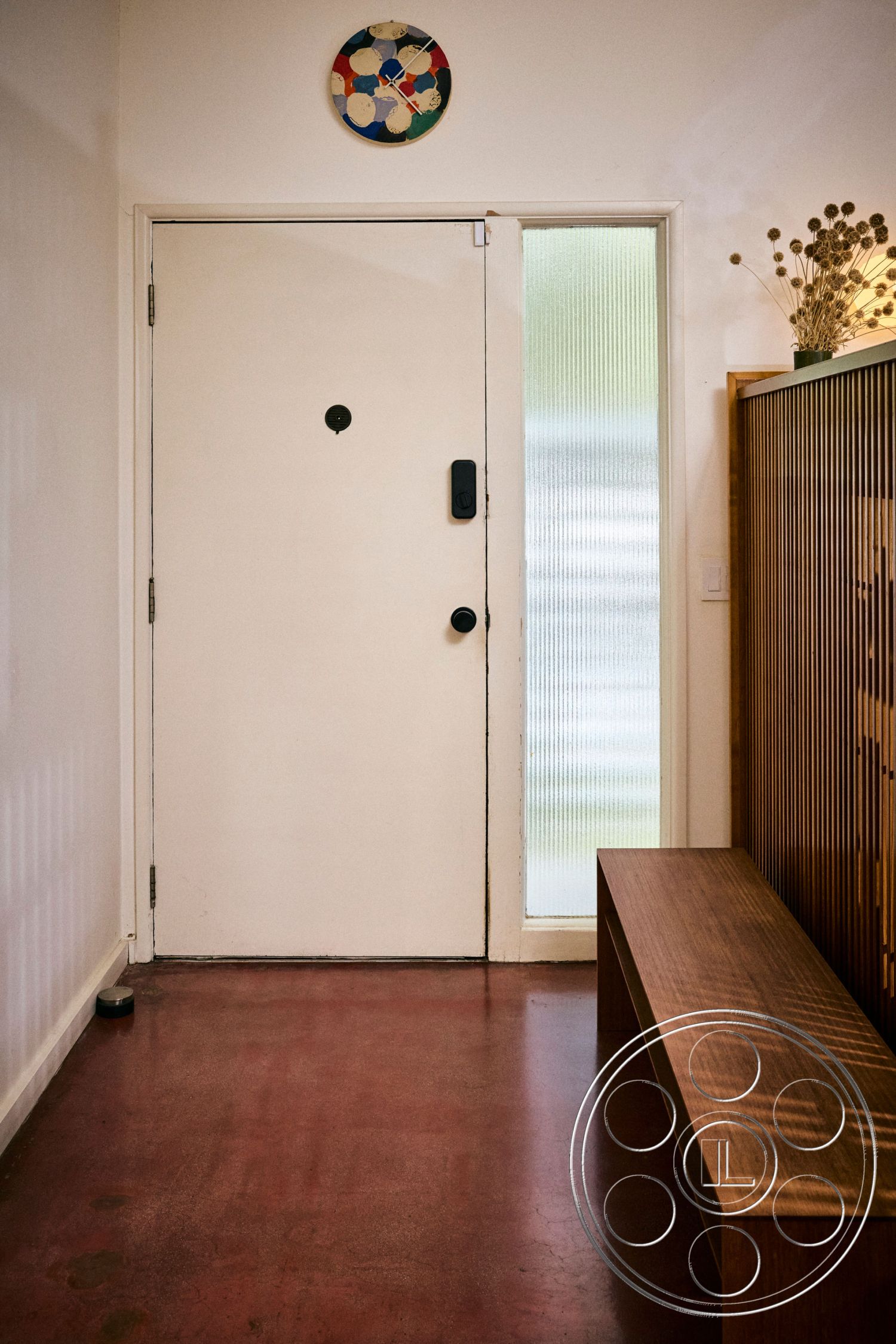 MCM 26 - minimalist decor, polished concrete floor, concrete flooring, modern wall clock, glass entry door, white painted walls, wood bench seating, interior entryway, vertical wood slat wall, simple entryway design