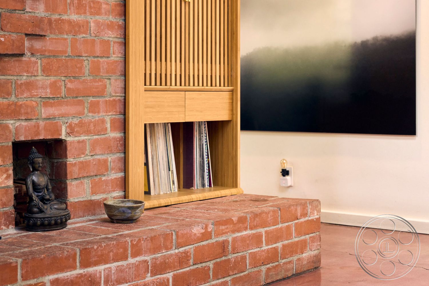 MCM 26 - natural wood cabinetry, textured plaster walls, interior living space, minimalist decor elements, concrete floor finish, exposed brick accent wall, wood shelving unit, red brick fireplace surround, modern art wall decoration, Buddha statue decor