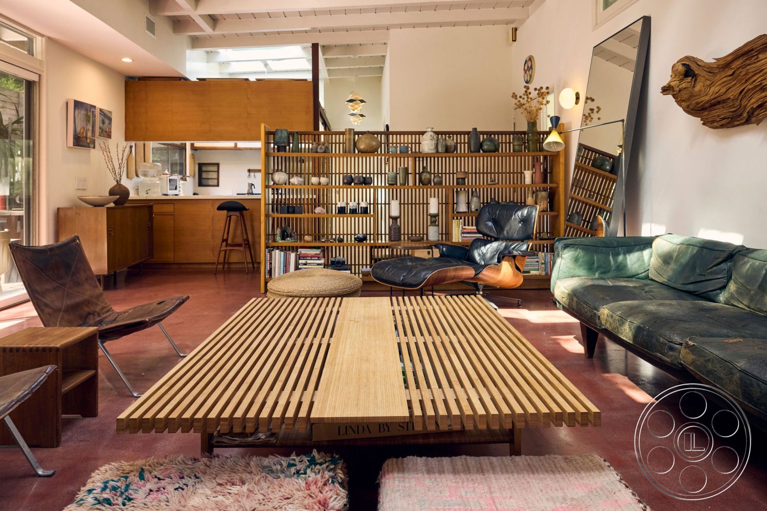 MCM 26 - interior, exposed wood ceiling beams, vaulted ceilings, interior, polished concrete floors, living room flooring, interior, mid-century modern style, open floor plan, interior, wooden kitchen cabinets, walnut cabinetry, interior, glass door partitions, natural light, interior, bamboo slatted coffee table, modern furniture, interior, leather lounge chair, contemporary seating, interior, decorative shelving, minimalist design, interior, plush area rug, textured flooring, interior, cozy reading nook, natural materials, interior, gallery wall, framed artwork, interior, warm lighting, ambient decor