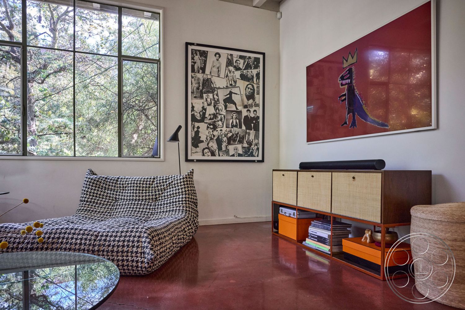 MCM 26 - natural light, functional decor, polished concrete flooring, modern lighting fixtures, textured walls, minimalistic design, urban environment, open living space, greenery views, artistic wall décor, large sliding glass windows, colorful framed artwork, black and white houndstooth chaise lounge, mid-century modern storage cabinet, contemporary artistic style