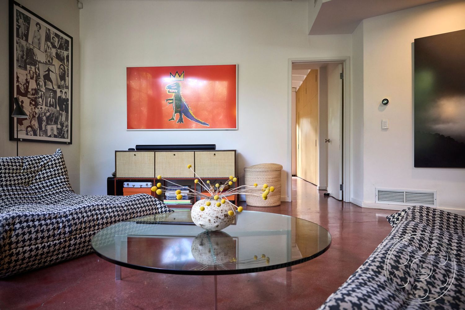 MCM 26 - polished concrete floor, open floor plan, glass coffee table, textured accent wall, minimalist style, modern decor elements, mid-century modern furniture, natural light exposure, houndstooth patterned upholstery, melamine cabinetry, framed black and white photo wall, vibrant wall art, functional living room, curved doorways