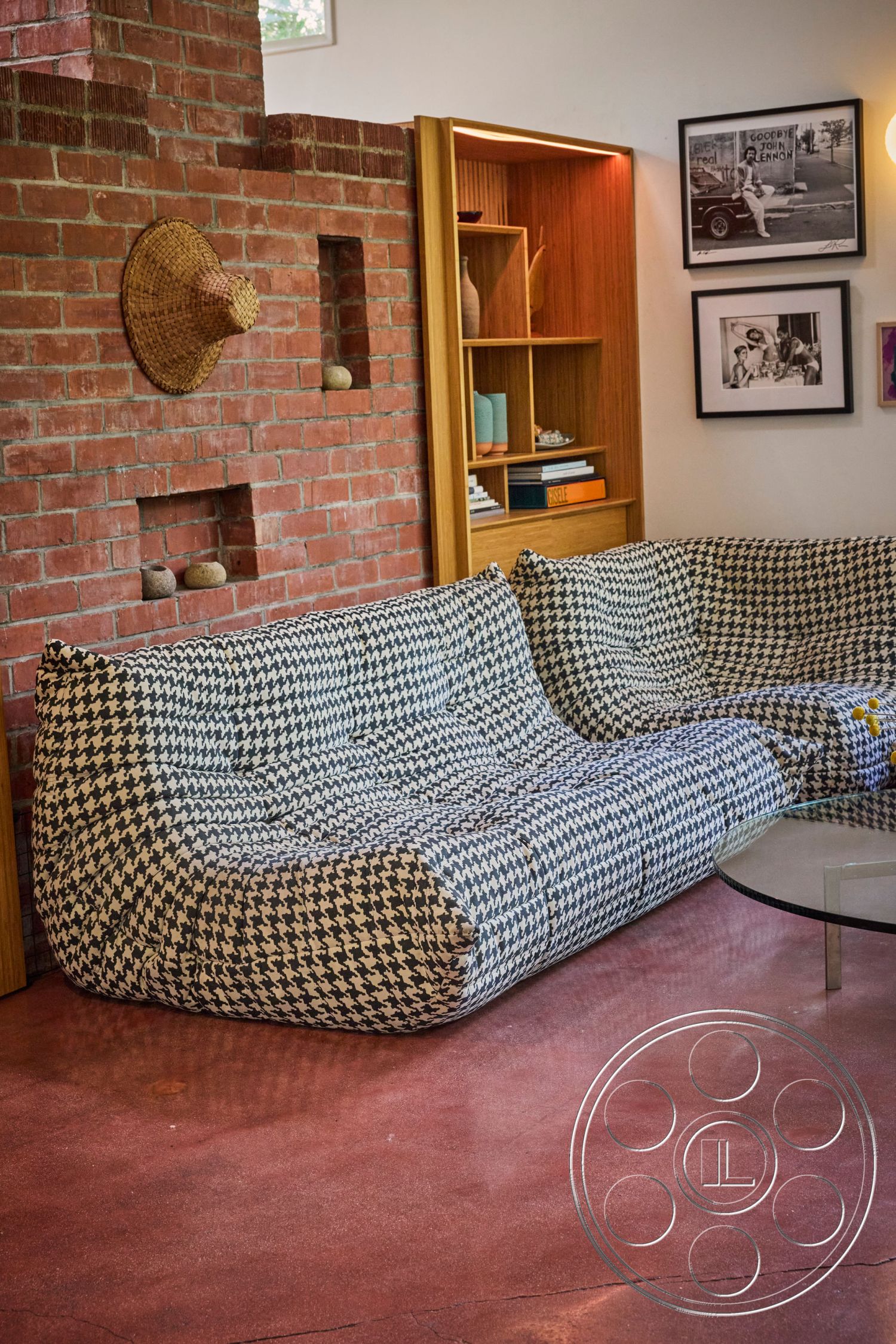 MCM 26 - natural light, concrete floor, glass coffee table, artwork displays, warm ambient lighting, textured plaster walls, exposed brick accent wall, built-in wooden shelves, modern modular sofa