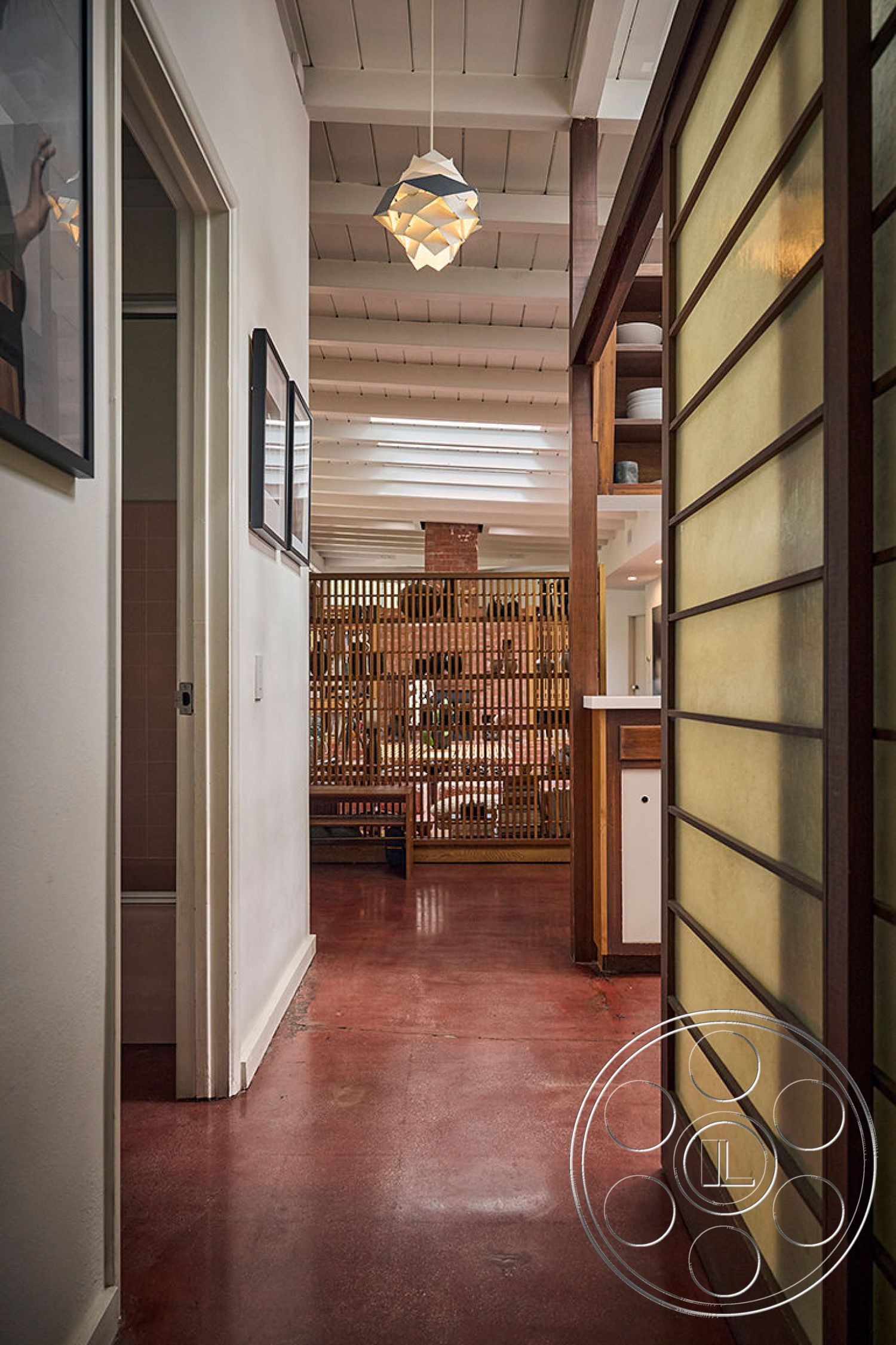 MCM 26 - natural wood accents, warm color palette, open concept living space, textured wall treatments, wood beam ceiling, built-in storage solutions, exposed brick accent wall, mid-century modern interior design, polished concrete hallway flooring, sliding glass partition doors, feature lighting pendant fixtures