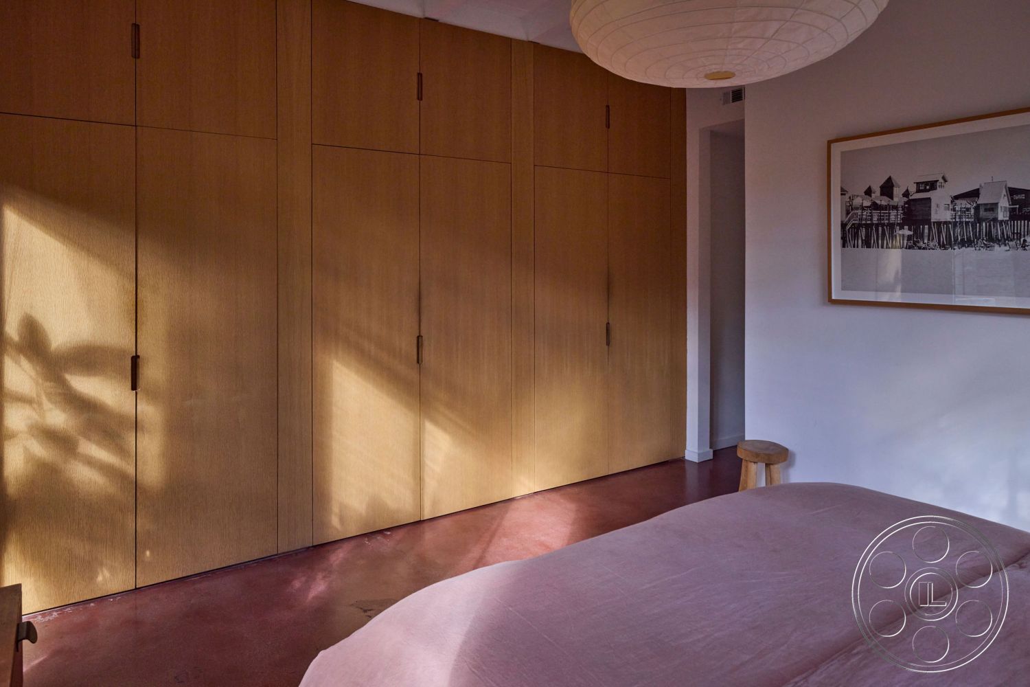 MCM 26 - neutral color palette, open space layout, ambient lighting fixtures, contemporary art piece, interior polished concrete flooring, interior hardwood closet doors, mid-century modern bedroom, minimalist aesthetic room decor, light wood paneling features, soft pink velvet bedding, natural light shadow play on walls, custom built-in wardrobes, simple modern furniture design, textured wall effects, minimalist stool furniture