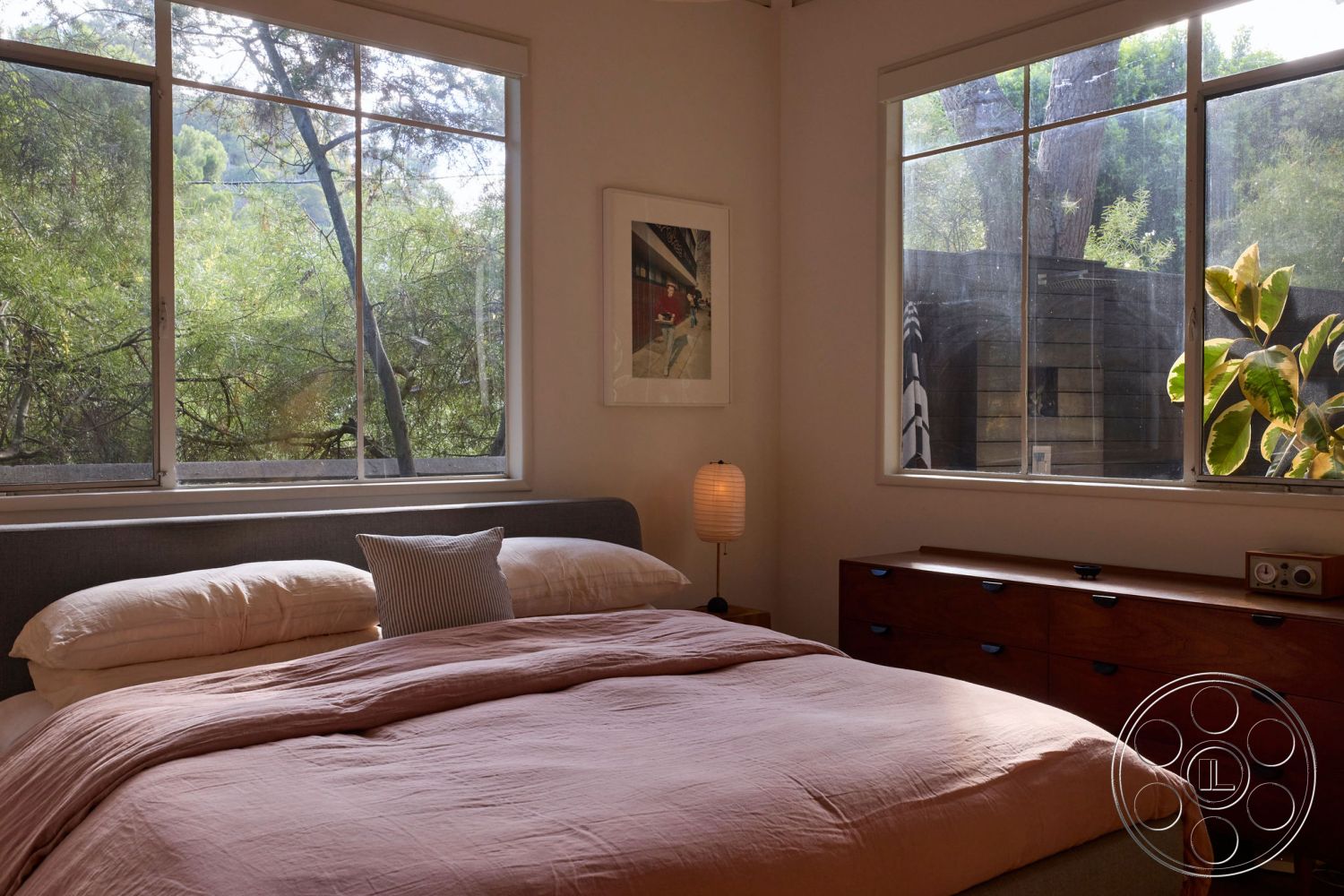 MCM 26 - neutral color palette, minimalist design, contemporary artwork, cozy atmosphere, open floor plan, wooden dresser, scandinavian style, textured bedding, natural light-filled space, hardwood bedroom floors, outdoor greenery view, large picture windows, plaster interior walls, modern bedside lamp, stylized accent decor