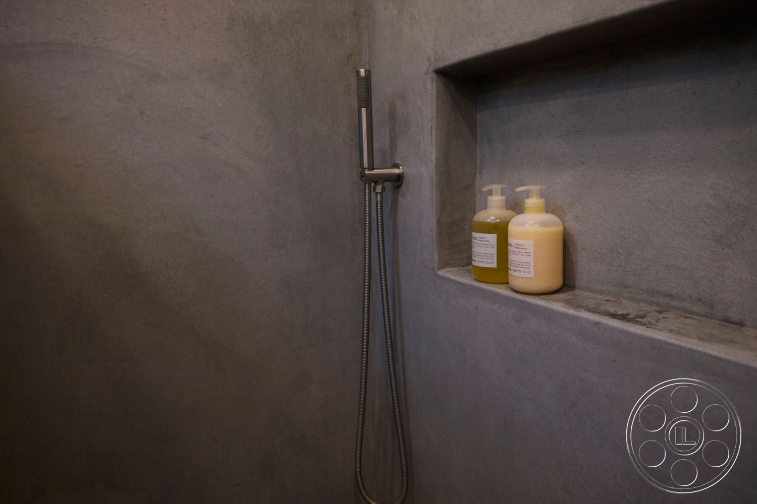 MCM 26 - neutral color palette, monochromatic color scheme, open shower concept, minimalist bathroom design, modern bathroom interior, textured concrete surfaces, functional bathroom storage, concrete shower walls, concrete recess shelf, stainless steel shower fixture, fixed shower head, industrial style bathroom