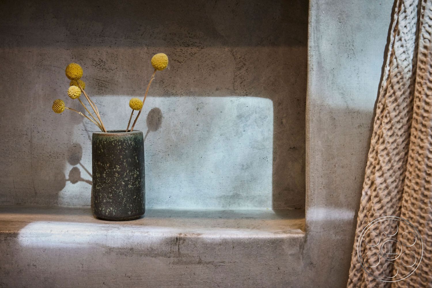 MCM 26 - neutral color palette, natural light, exposed concrete wall, industrial decor elements, minimalist interior, textured plaster finish, modern design aesthetic, ceramic vase with dried flowers, concrete shelf, soft, ambient lighting