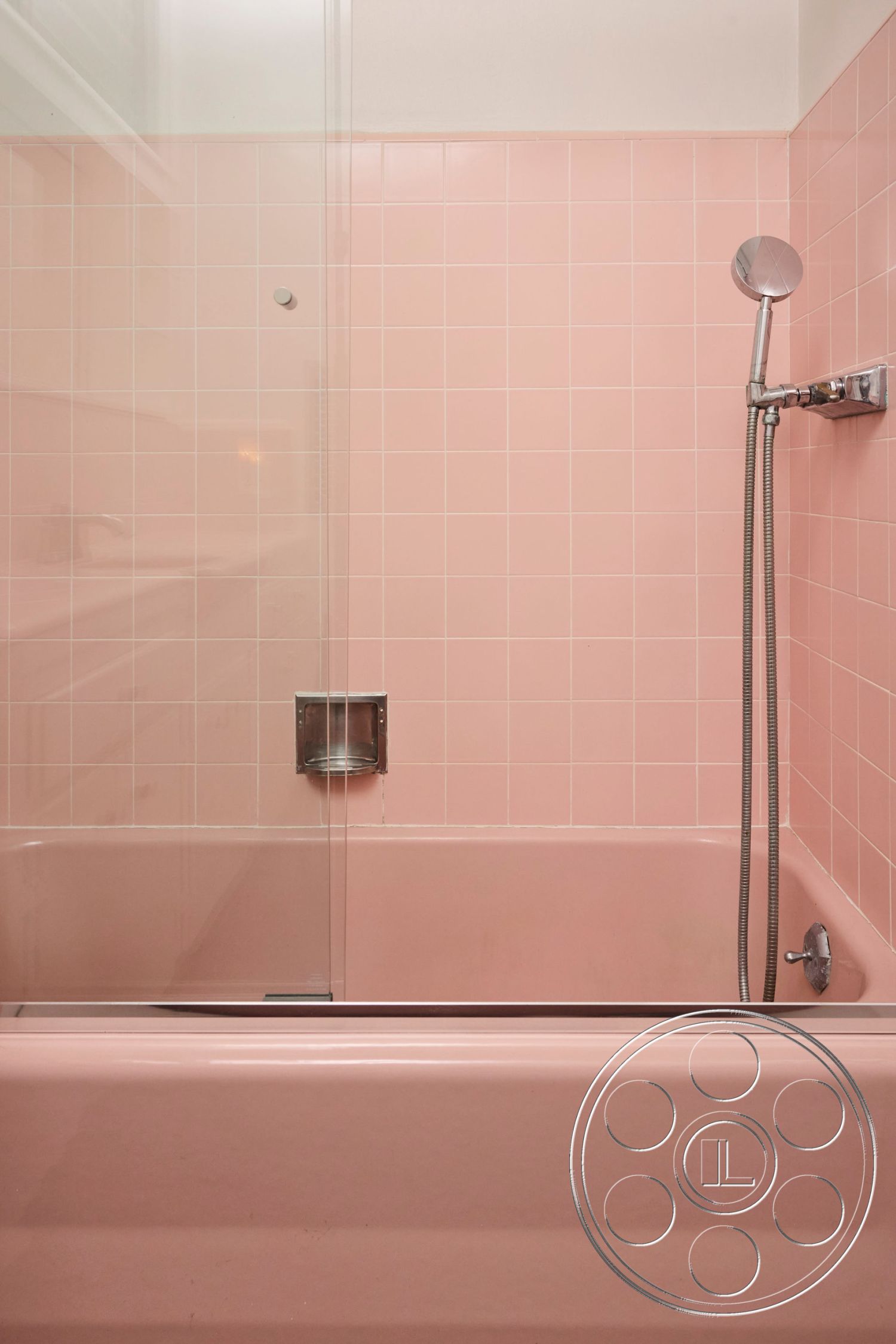 MCM 26 - interior modern bathroom fixtures, interior minimalist shower design, interior pink tile bathroom walls, interior pink bathtub with glass shower doors, interior tiled wall with square pink tiles, interior chrome showerhead, interior clean lines and simple forms, interior functional bathtub-shower combination