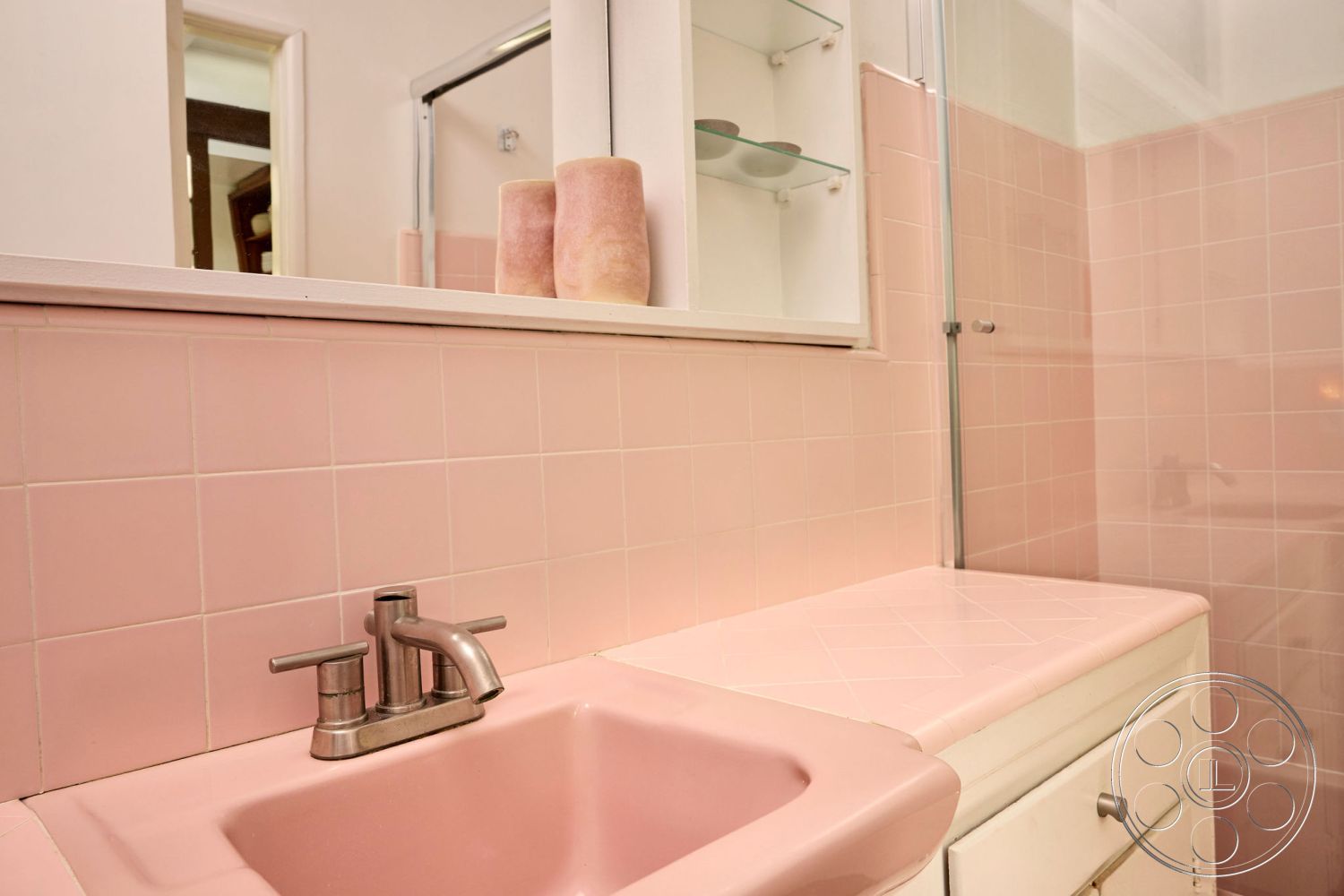 MCM 26 - glass shower enclosure, neutral color scheme, modern bathroom lighting, interior bathroom, built-in bathroom storage, stainless steel bathroom faucet, pink ceramic bathroom tile walls, pink porcelain sink, white laminate countertop, traditional bathroom design