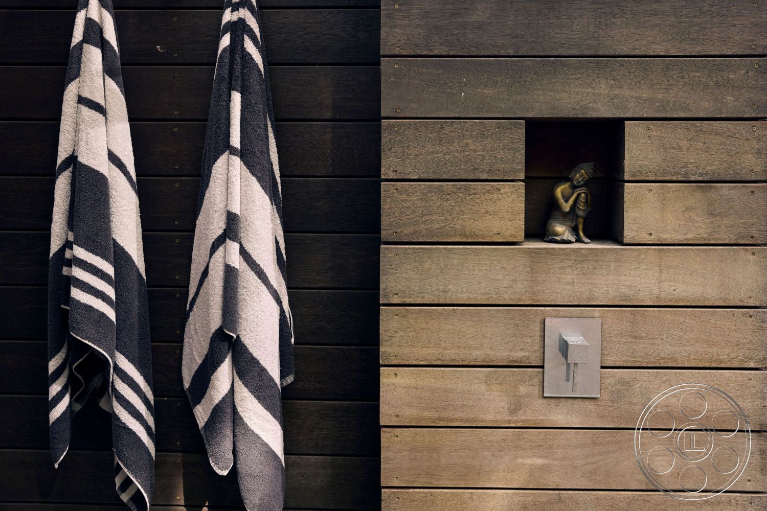 MCM 26 - minimalist outdoor design, wood slat wall treatment, modern exterior shower area, bronze sculpture accent, stainless steel water fixture, two-tone striped towels, textured wood planks, contemporary bath space, spa-inspired setting, interior and exterior blend