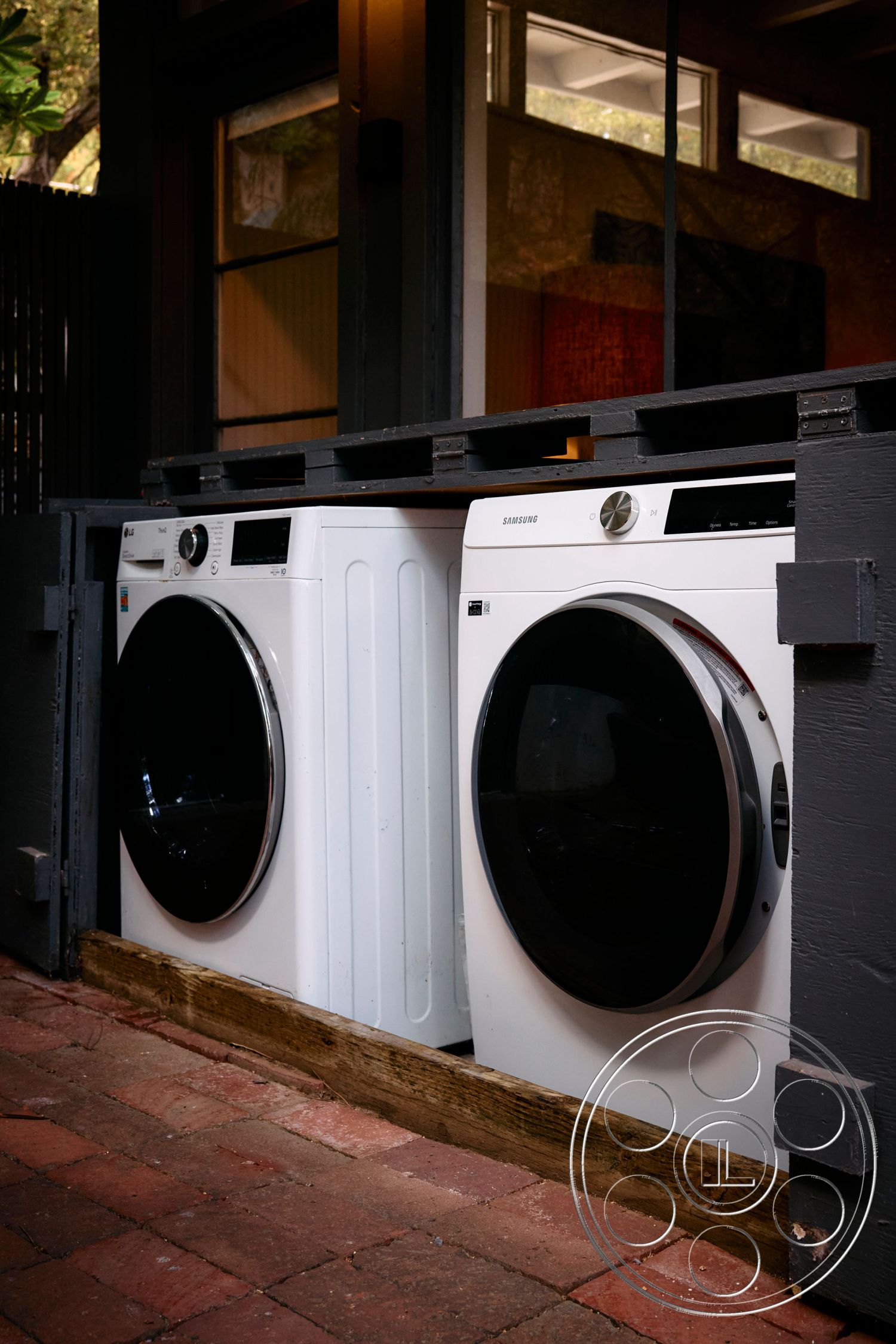 MCM 26 - natural light, minimalist style, open-plan design, interior laundry area, brick paver flooring, stainless steel washer and dryer, wood frame cabinetry, black glass front appliances, modern laundry space