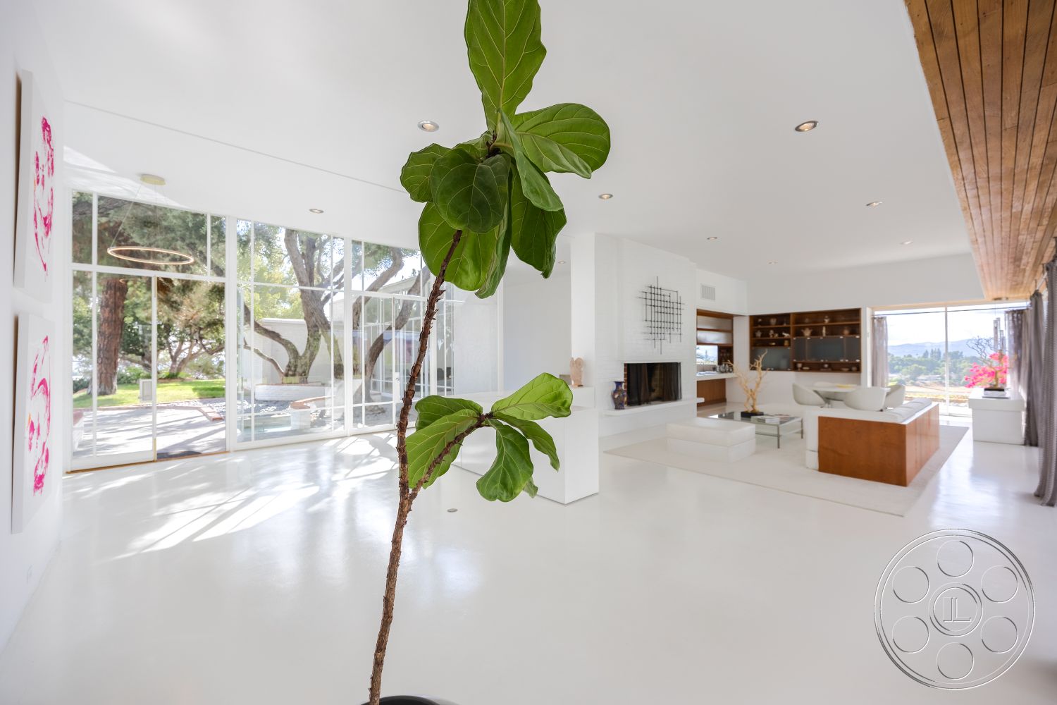 Sinatra House - natural light, concrete flooring, modern furnishings, landscaped garden view, floor-to-ceiling windows, outdoor terrace, hillside location, white concrete walls, open-plan layout, urban modern, glass partition walls, wood beam ceiling, stone fireplace wall, contemporary art accents, minimalist living room design