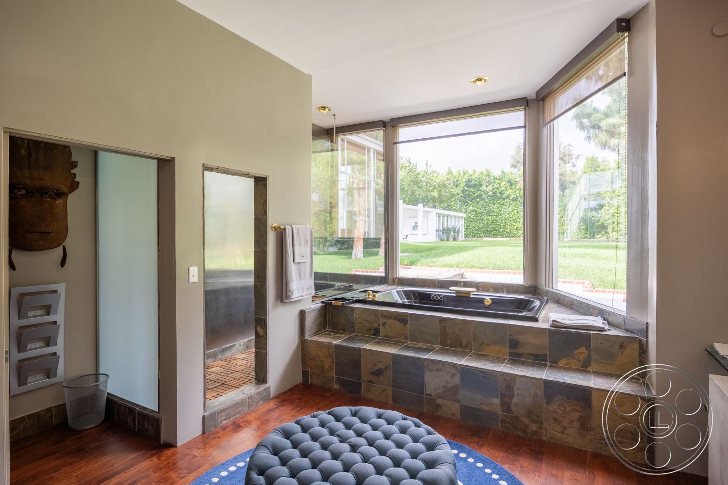 Sinatra House - natural stone countertop, soft color palette, textured plaster wall finish, modern freestanding bathtub, functional storage solutions, floor-to-ceiling glass windows, clean lines architecture, high ceilings with recessed lighting, minimalist interior, hardwood bathroom flooring, slate tile bathtub surround, exposed stone tub base, decorative wood accent panel, open bathroom layout, dual-function shower with glass door, contemporary window treatments, luxurious spa atmosphere, sunlit bathroom environment, serene garden view, peaceful outdoor access