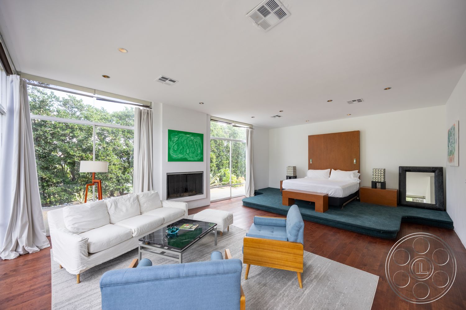 Sinatra House - neutral color palette, minimalist design, textured area rug, contemporary furniture, garden view, suburban setting, floor-to-ceiling windows, vaulted ceiling, relaxing atmosphere, urban retreat, comfortable seating area, natural light-filled space, hardwood bedroom floors, modern fireplace surround, open-concept interior, wall-mounted art display, sleek bedding, wood accent wall behind bed, wraparound curtain treatment, glass sliding door to garden