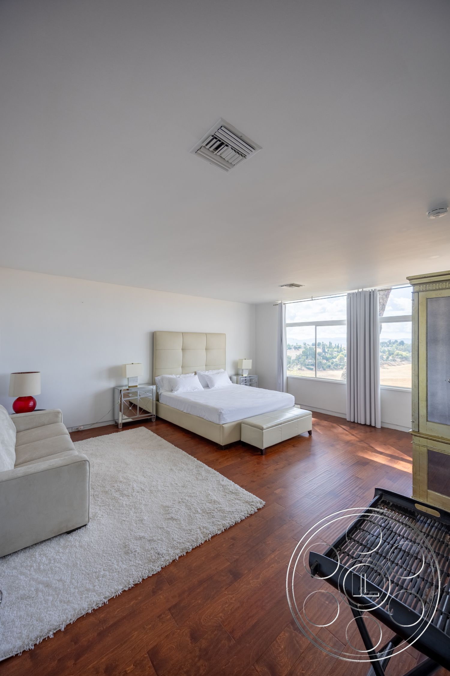 Sinatra House - floor-to-ceiling windows, soft natural light, textured wall treatment, plush area rug, stylish accent chair, hardwood bedroom floors, white painted walls, minimalist bedside lamps, modern platform bed, contemporary leather headboard, glass nightstands, exposed ceiling light fixture