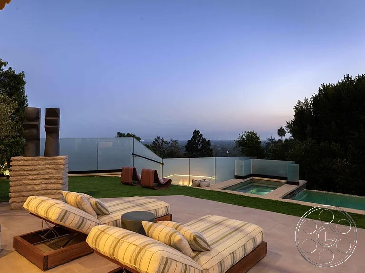 Modern 512 - modern outdoor seating area, minimalist architectural design, city skyline view at dusk, exterior patio with concrete flooring, rectangular pool with stone coping, glass railing surrounding pool area, landscape garden in urban setting, plush outdoor lounge chairs with striped upholstery, green lawn for outdoor activities, sculptural elements incorporated in landscape design, hardscape patio with built-in seating