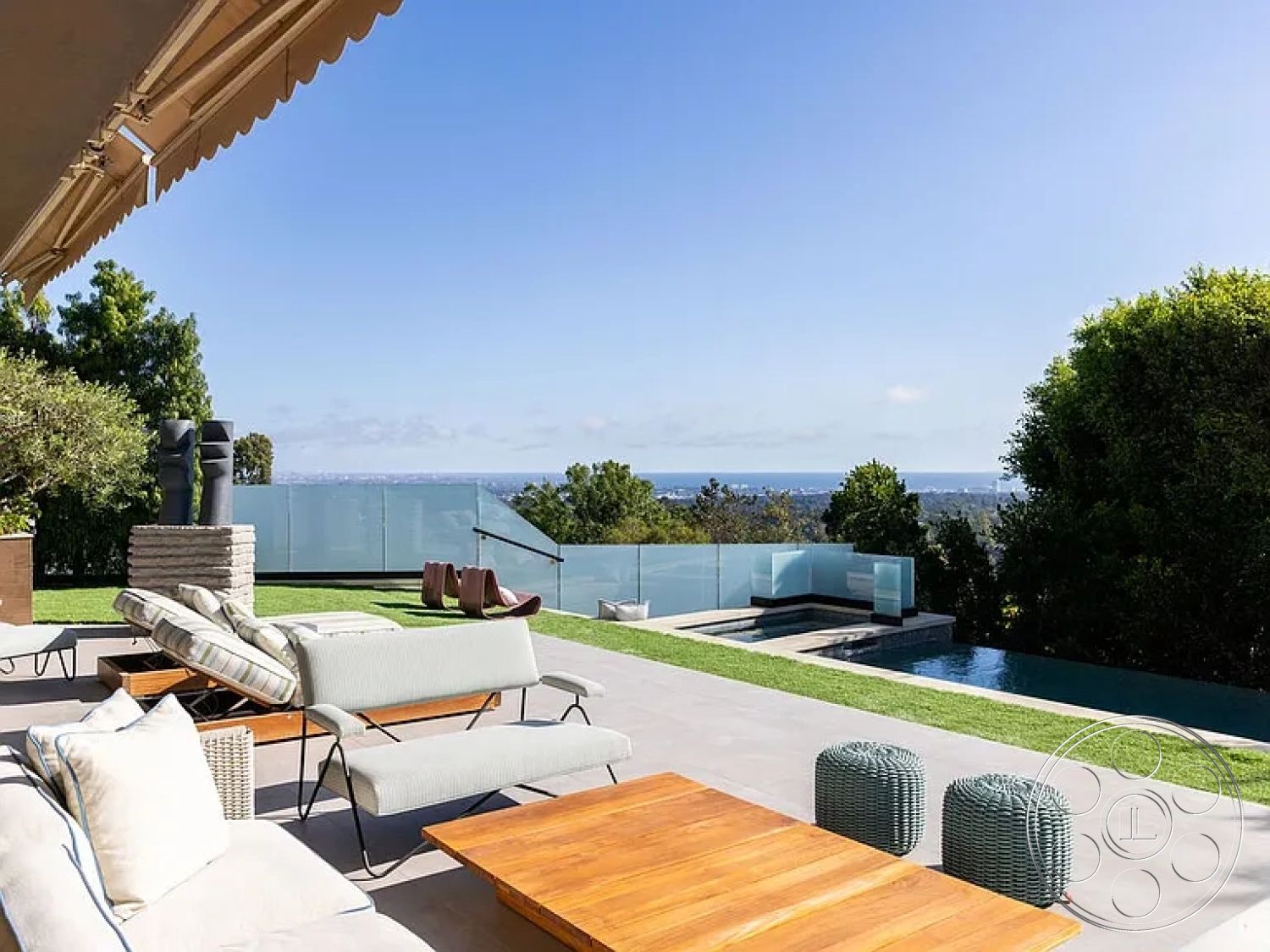 Modern 512 - exterior, landscaped garden, large glass sliding doors, wooden coffee table, minimalist design elements, modern outdoor furniture, city skyline view, textured concrete patio, sunny outdoor space, contemporary architectural style, stone patio flooring, open-air lounge area, rectangular infinity pool, green lawn setting, glass pool railing, uplighting for outdoor ambiance