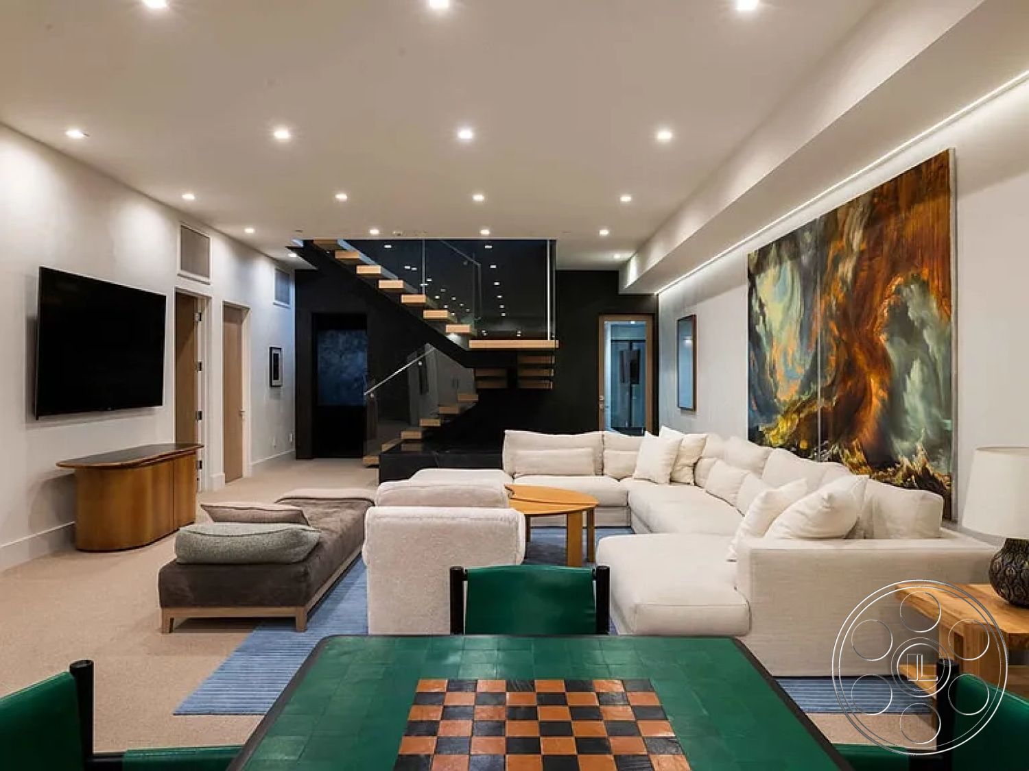 Modern 512 - recessed lighting, light-colored walls, textured accent wall, minimalist design elements, plush sectional sofa, carpeted flooring, contemporary coffee table, open-plan layout, wall-mounted artwork, round wooden side table, interior living room, cozy entertainment space, modern art piece, hardwood staircase with glass railing, neutral upholstered cushions, multicolored patterned area rug, flat-screen wall-mounted TV, game table with green felt, vaulted ceiling with sleek lighting