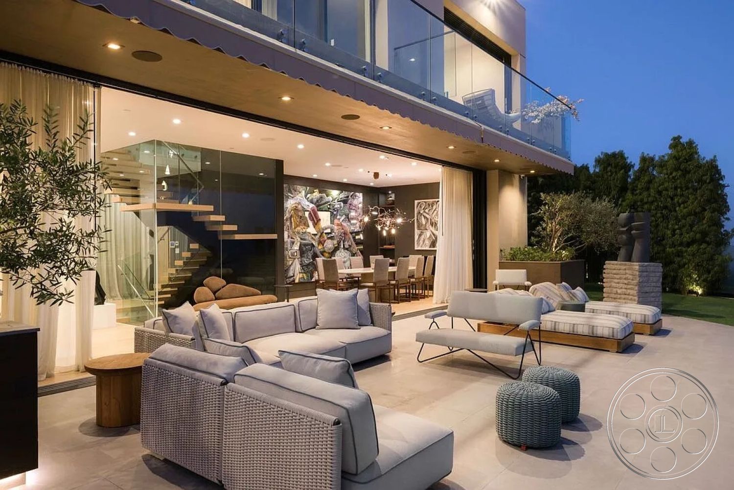 Modern 512 - stone accent wall, wooden coffee table, glass sliding doors, floor-to-ceiling windows, woven outdoor furniture, open-concept living space, contemporary design elements, city skyline view, dim ambient lighting, textured fabric cushions, modern outdoor seating, concrete patio floor, steel railing details, floating wooden staircase, exterior patio lounge area, outdoor garden planters, surrounding landscaped garden, shade extension overhang, luxury modern villa, white shear curtains