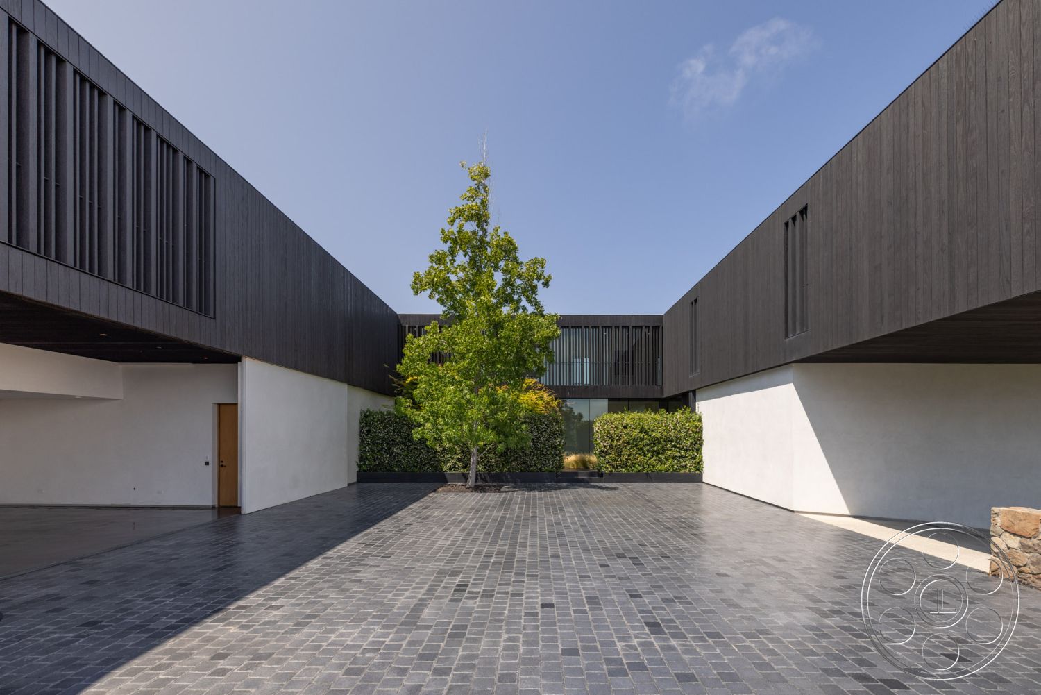 Modern 513 - exterior, minimalist design elements, outdoor living space, modern architectural style, large floor-to-ceiling windows, concrete foundation, stucco wall treatment, courtyard design, slate stone patio flooring, black wood siding exterior, built-in greenery landscaping, rectangular shapes in construction, asymmetrical building profiles, landscaped garden with mature trees