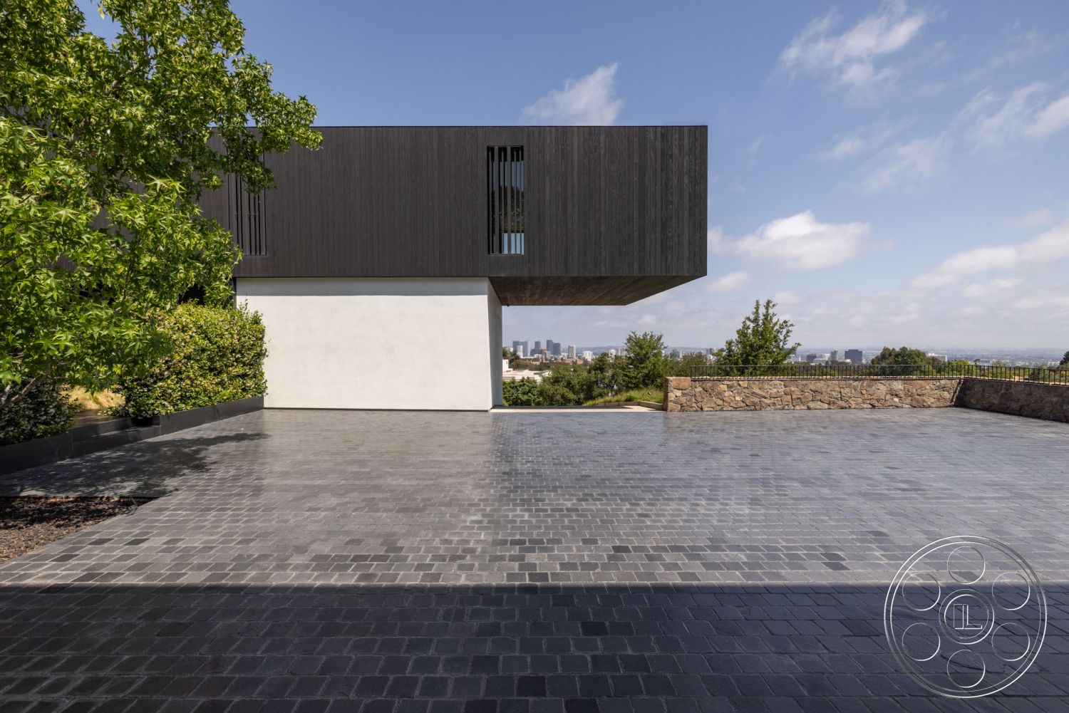 Modern 513 - exterior, minimalist aesthetic, city skyline view, concrete driveway, contemporary home, modern architectural design, landscaped outdoor area, steel railing details, rectangular pavers, wooden cantilevered facade, landscaped garden border, slate stone walls, textured gray surface