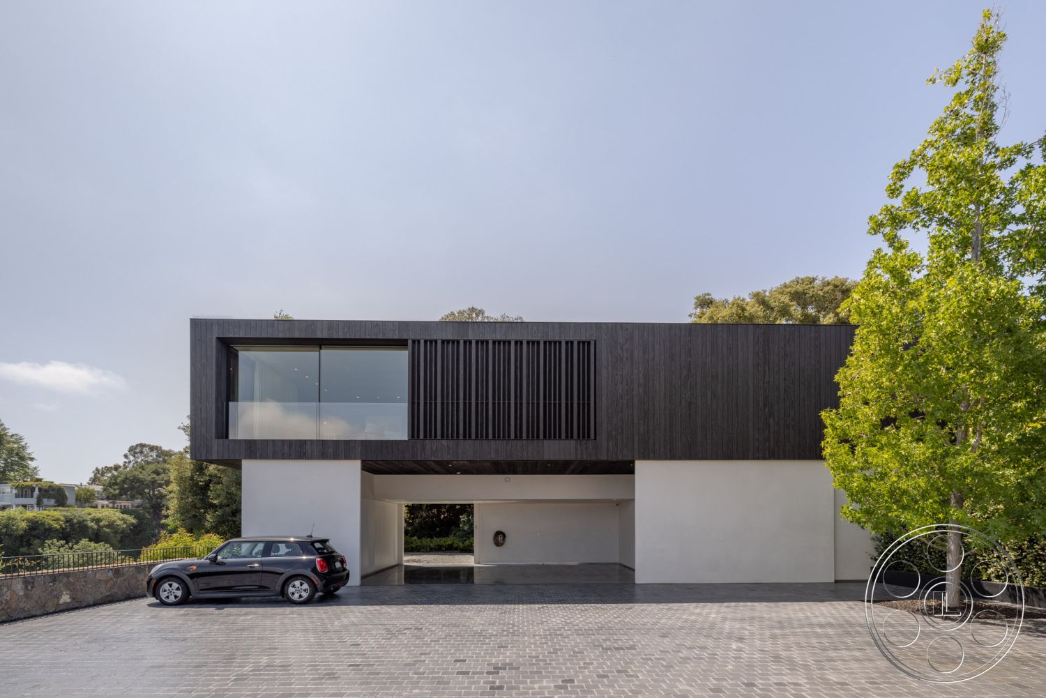 Modern 513 - exterior, minimalist aesthetic, large glass windows, surrounding greenery, landscaped front yard, modern architectural style, concrete driveway, flat roof design, corner window design, textured wall details, steel support beams, wood cladding facade, paved entrance path, garage with car port, rectangular structure