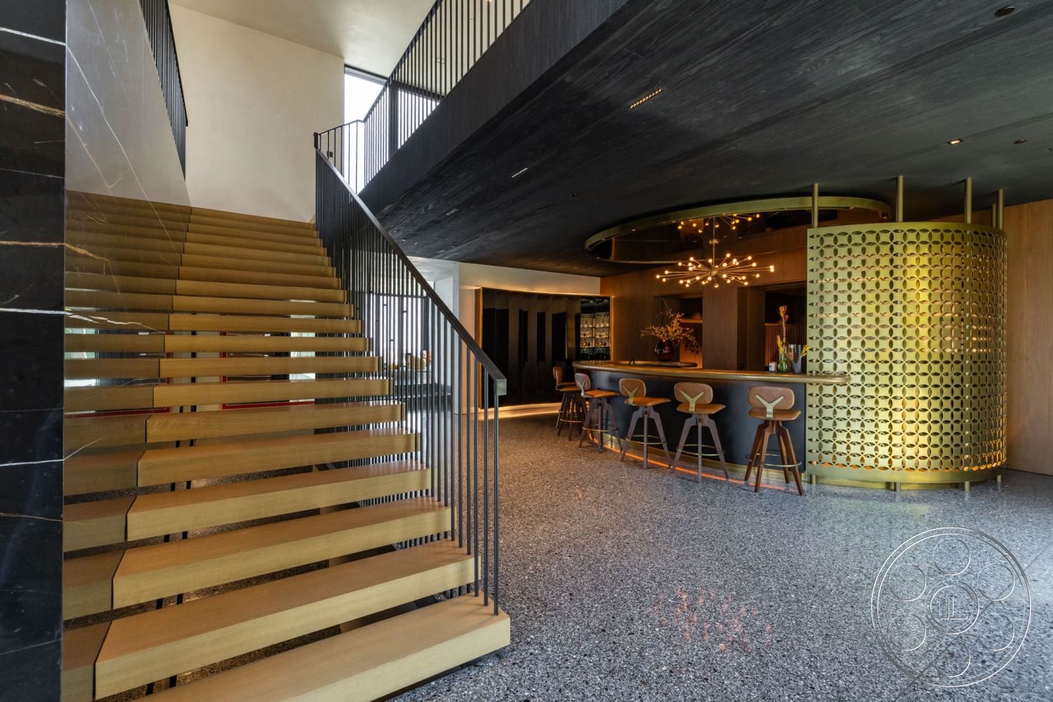 Modern 513 - interior neutral color palette, interior modern pendant lighting, interior natural light, interior floor-to-ceiling windows, interior open concept layout, interior minimalist design elements, interior textured wall paneling, interior wooden bar stools, interior contemporary style, interior concrete terrazzo flooring, interior wooden staircase with open risers, interior black marble accent wall, interior gold circular bar with decorative screen, interior angled ceiling design