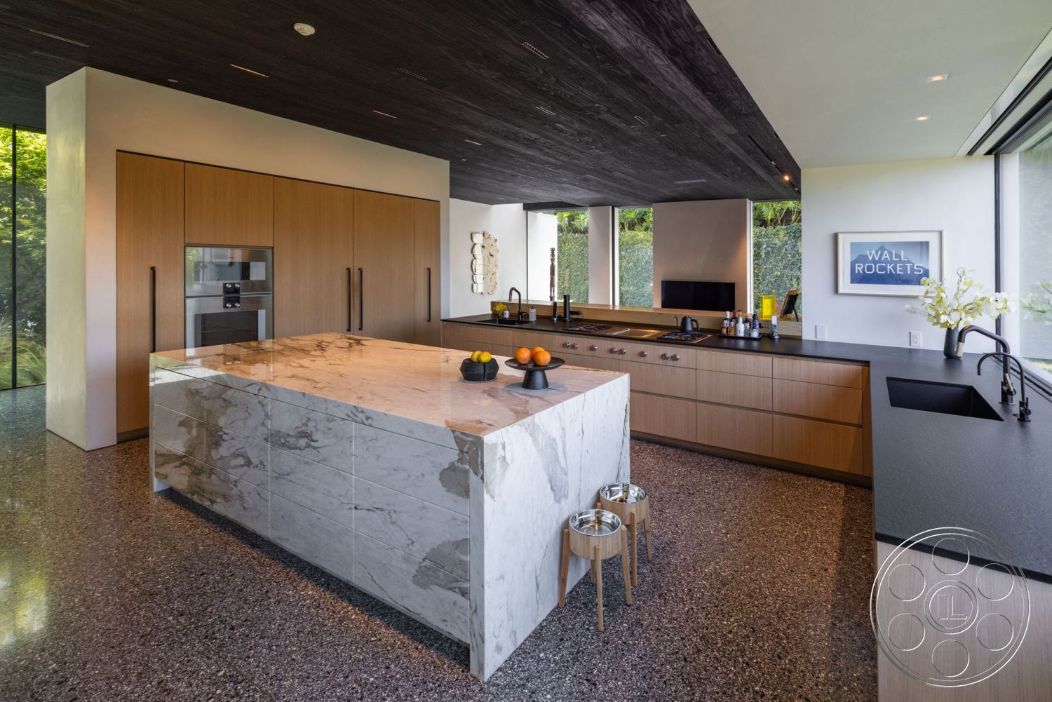 Modern 513 - neutral color palette, natural light, terrazzo flooring, minimalist aesthetic, wood cabinetry, open concept layout, floor-to-ceiling windows, decorative wall art, black granite countertop, fruit bowl centerpiece, modern kitchen design, contemporary architectural style, interior kitchen space, integrated kitchen appliances, marble kitchen island, exposed wood ceiling, sleek black kitchen sink