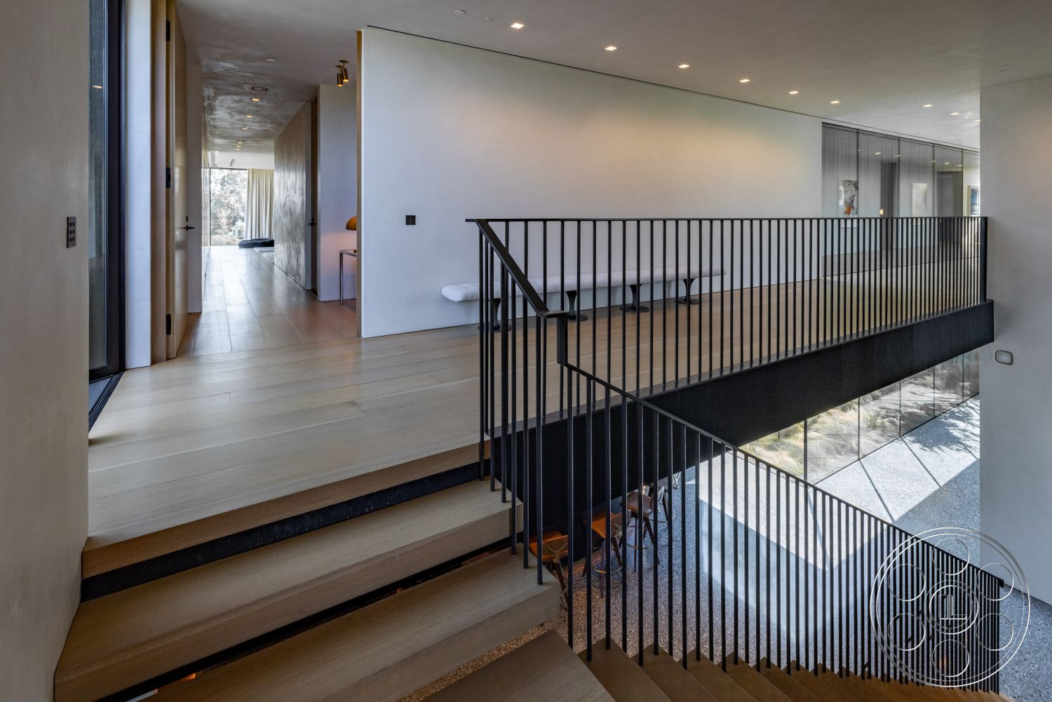 Modern 513 - neutral color palette, indoor-outdoor flow, exposed concrete walls, modern minimalist design, interior hardwood flooring, contemporary art decor, textured plaster wall finish, open concept living area, floor-to-ceiling glass windows, clean lines architecture, high ceilings with recessed lighting, metal stair railings, streamlined furniture design, spacious hallway with natural light, interior glass railing staircase, windows providing natural light