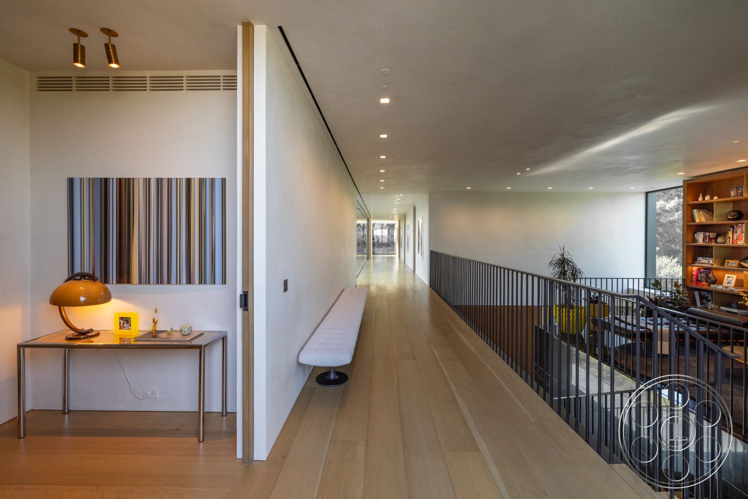 Modern 513 - hardwood flooring, geometric wall art, floor-to-ceiling windows, neutral wall color, textured plaster walls, natural wood trim, large windows with natural light, modern recessed lighting, contemporary minimalist design, clean line aesthetic, smooth ceiling finish, open hallway interior, steel railing with wood accents, floating bench seating, expansive corridor, minimalist home office nook, stylish accent lamp, decorative table with personal items