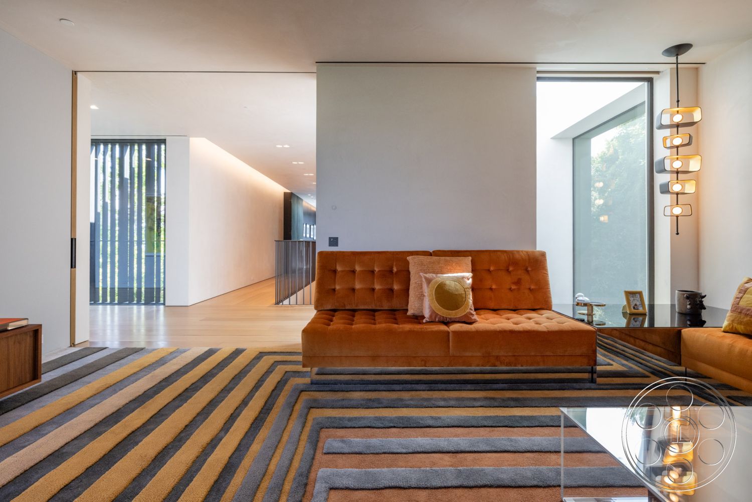 Modern 513 - hardwood flooring, open floor plan, exposed beam ceiling, glass coffee table, modern lighting fixtures, floor-to-ceiling windows, natural light from large windows, wooden accent furniture, modern art decor, interior living room, neutral painted walls, textured rug with geometric patterns, orange tufted sofa, minimalist wall design, contemporary architectural elements