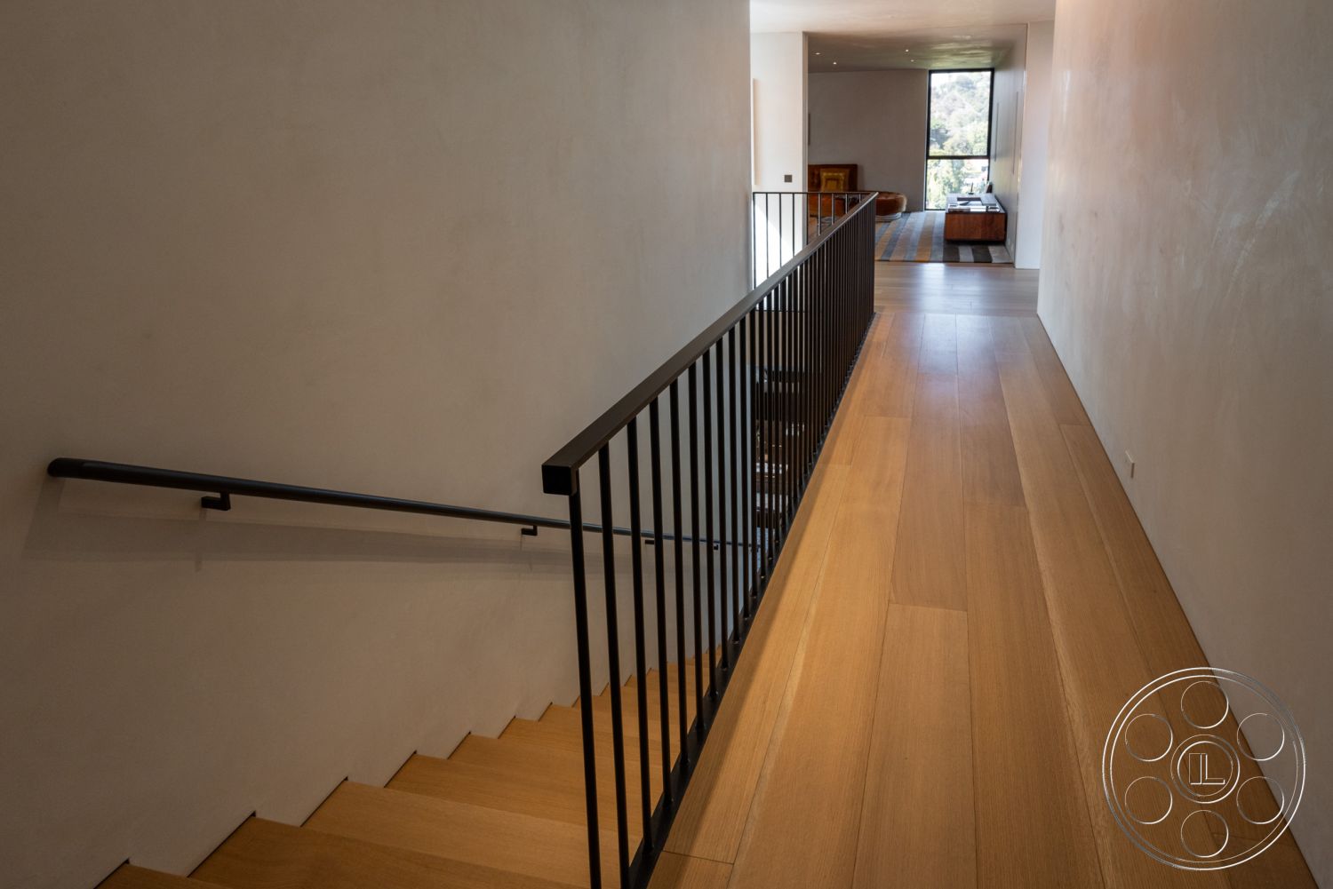 Modern 513 - interior natural light from large windows, interior minimalist design, interior natural wood accents, interior smooth plaster walls, interior modern architectural details, interior hardwood hallway floors, interior open riser staircase, interior black steel stair railings, interior contemporary hallway, interior spacious corridor