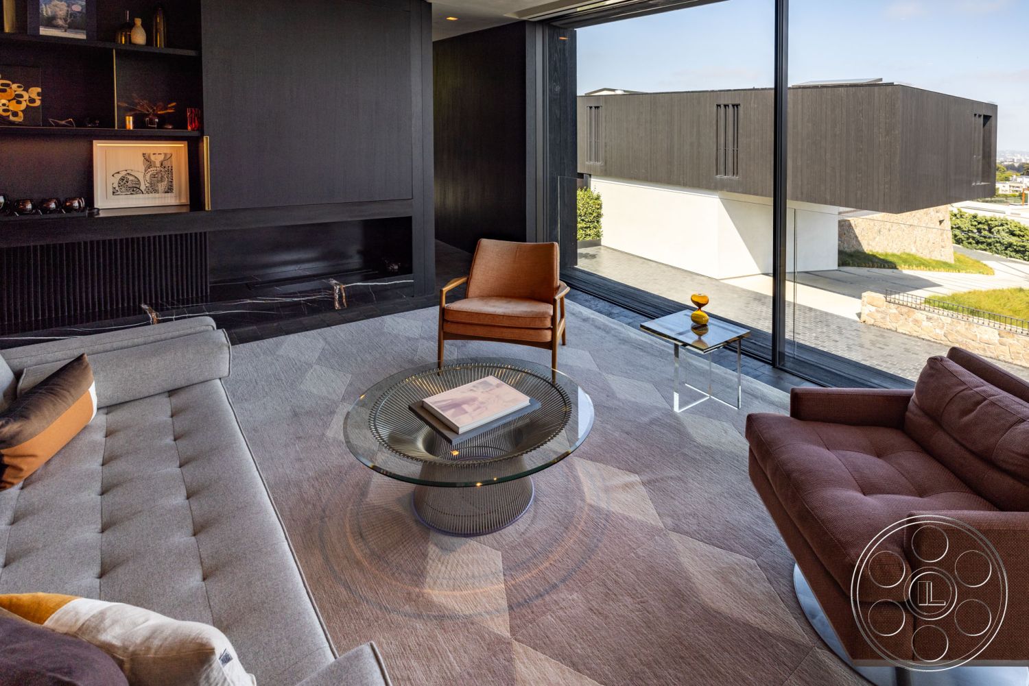 Modern 513 - minimalist decor, neutral color palette, open floor plan, geometric area rug, dark wood accent wall, round glass coffee table, interior living room, natural light through large windows, sleek modern design, built-in shelving unit, glass wall with city view, contemporary sofa with multi-colored cushions, modern armchair in warm wood finish