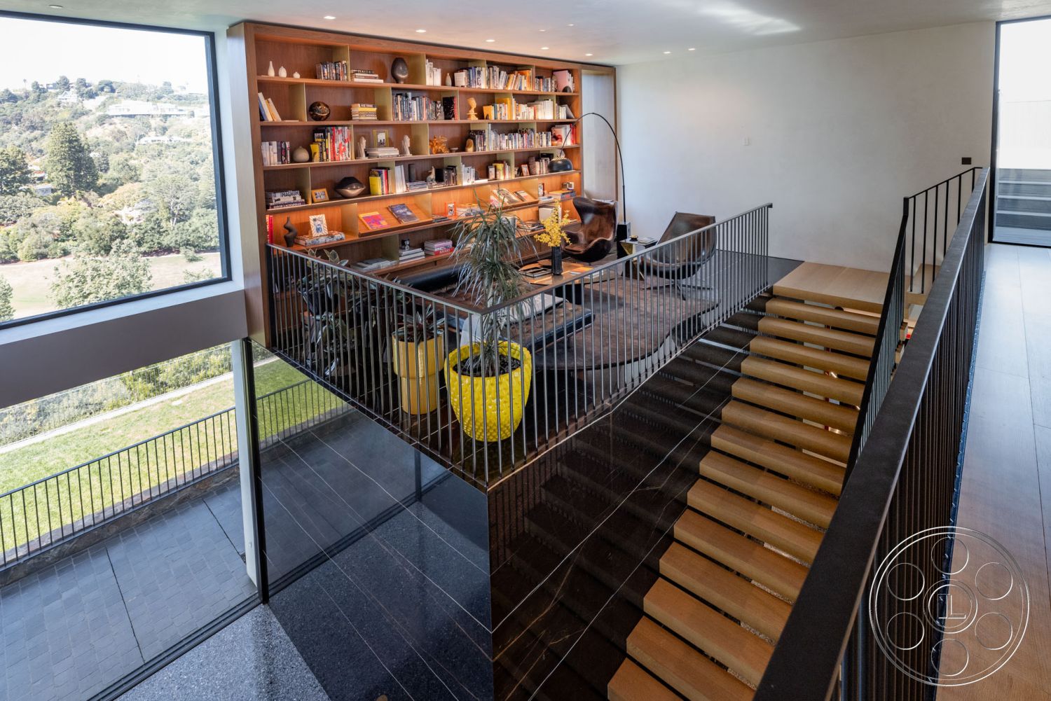 Modern 513 - interior cozy reading nook, interior hardwood living room floors, interior exposed wood ceiling beams, exterior landscaped garden, interior floor-to-ceiling windows, interior open floor plan, interior minimalist design, exterior hillside location, interior ambient lighting fixtures, interior decorative potted plants, interior glass railing staircase, interior built-in wooden bookshelves, interior curved stair design, interior concrete wall accents, interior modern armchairs, exterior panoramic view, interior light-colored walls