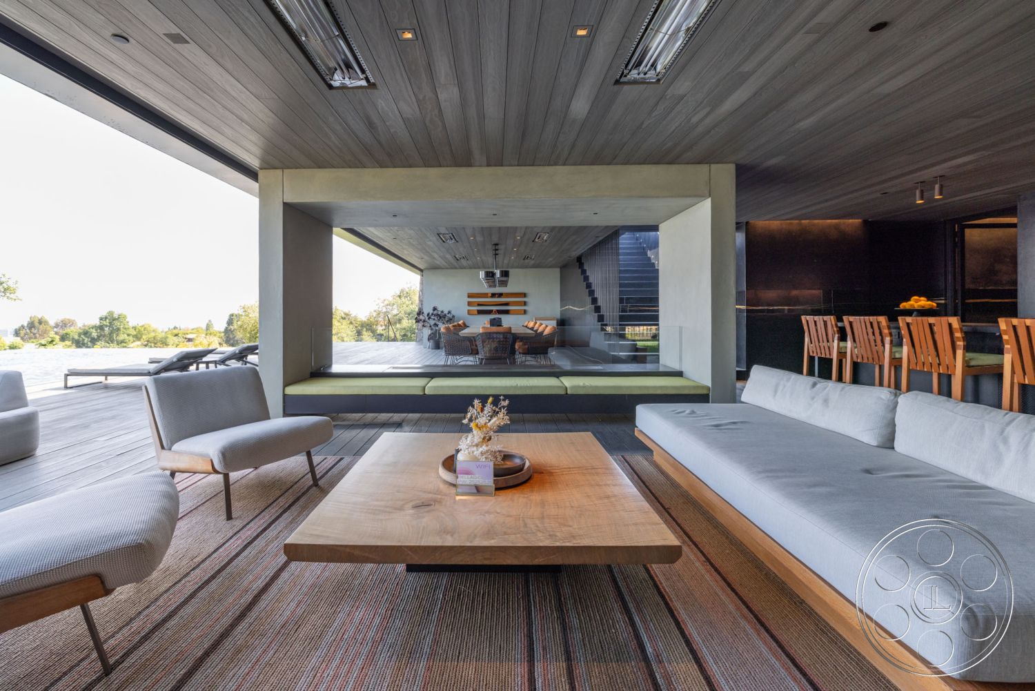 Modern 513 - contemporary furniture, polished concrete flooring, striped area rug, textured plaster walls, rectangular coffee table, wooden dining chairs, stylish lounge area, mountain view setting, mid-century modern architectural style, recessed ceiling lighting, minimalist interior design, natural lighting from large windows, open floor plan interior, glass partition wall, exposed wood ceiling, dining area with wooden table, light gray upholstered sofa, outdoor deck space, green built-in seating, modern crafted wood accents