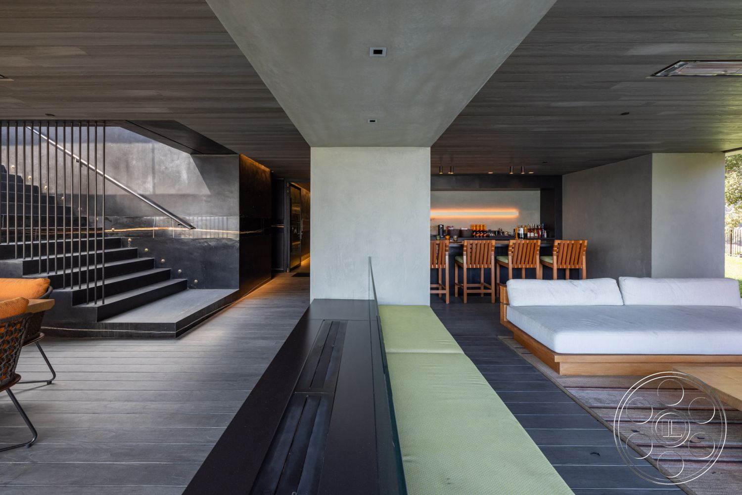 Modern 513 - floor-to-ceiling windows, open-concept living space, geometric area rug, contemporary dining area, textured plaster wall, wood beam ceiling, exposed concrete interior walls, black concrete staircase, hardwood floor panels in living area, modern stainless steel railing, built-in bar with wood cabinetry, minimalist low-profile sofa, rectangular sectional seating, interior space with indoor-outdoor flow, luxury modern space, urban setting with green views