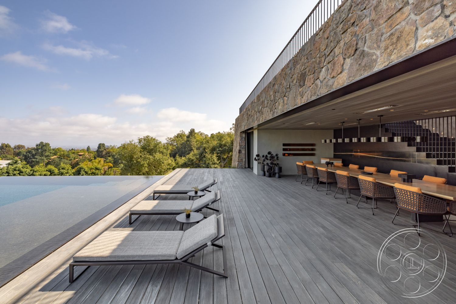 Modern 513 - exterior, sliding glass doors, glass railing, horizontal wood paneling, sunlit terrace, stone feature wall, natural landscape view, wooden deck flooring, contemporary architectural design, integrated outdoor kitchen, infinity pool edge, built-in outdoor seating, modern outdoor lounge chairs, lush green surroundings, expansive patio area, linear fire pit, open-concept outdoor dining space, large-format tile, elevated pool terrace, sleek minimalist aesthetic