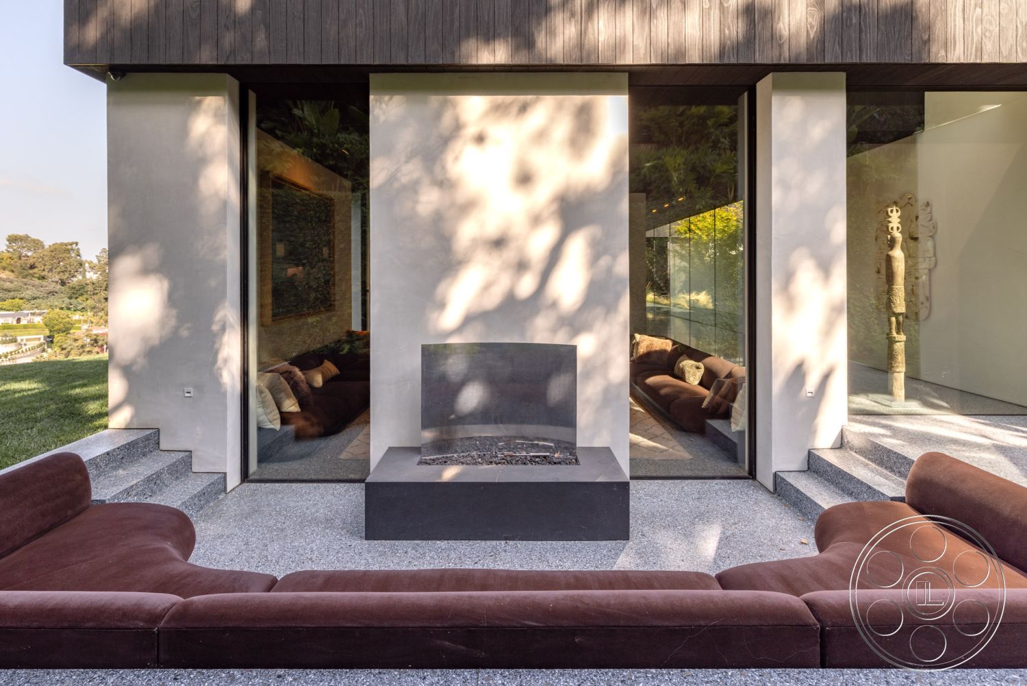 Modern 513 - exterior, minimalist design elements, glass sliding doors, landscaped garden view, floor-to-ceiling windows, gravel pathway, modern architectural style, modern outdoor lounge area, horizontal wood siding, concrete patio flooring, natural light integration, built-in seating area, scenic hillside location, open outdoor living space, textured concrete fire pit, brown sectional outdoor sofa, smooth stucco walls, abstract art wall feature