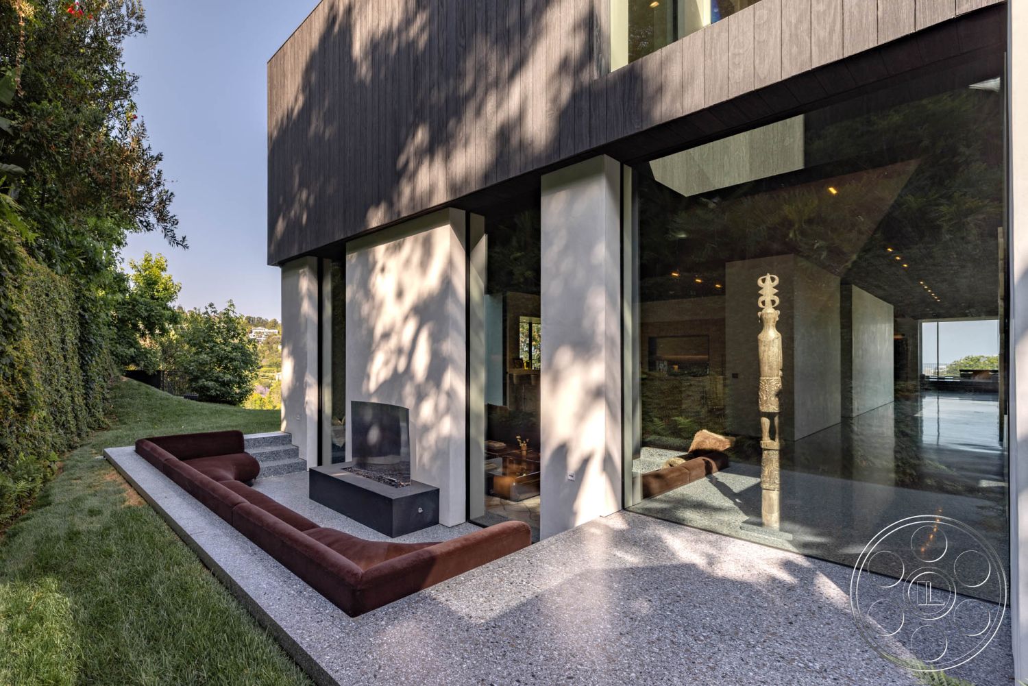 Modern 513 - floor-to-ceiling windows, landscaped backyard, open-concept layout, vertical wood siding, contemporary architectural style, lush garden setting, green lawn area, modern outdoor seating area, minimalist outdoor design, exterior glass walls, smooth concrete steps, exposed concrete patio flooring, rectangular concrete firepit, dark wood paneling exterior, sustainable landscaping features, vast city view, integrated indoor-outdoor living space, textured stone accents near patio, concrete base for outdoor furniture