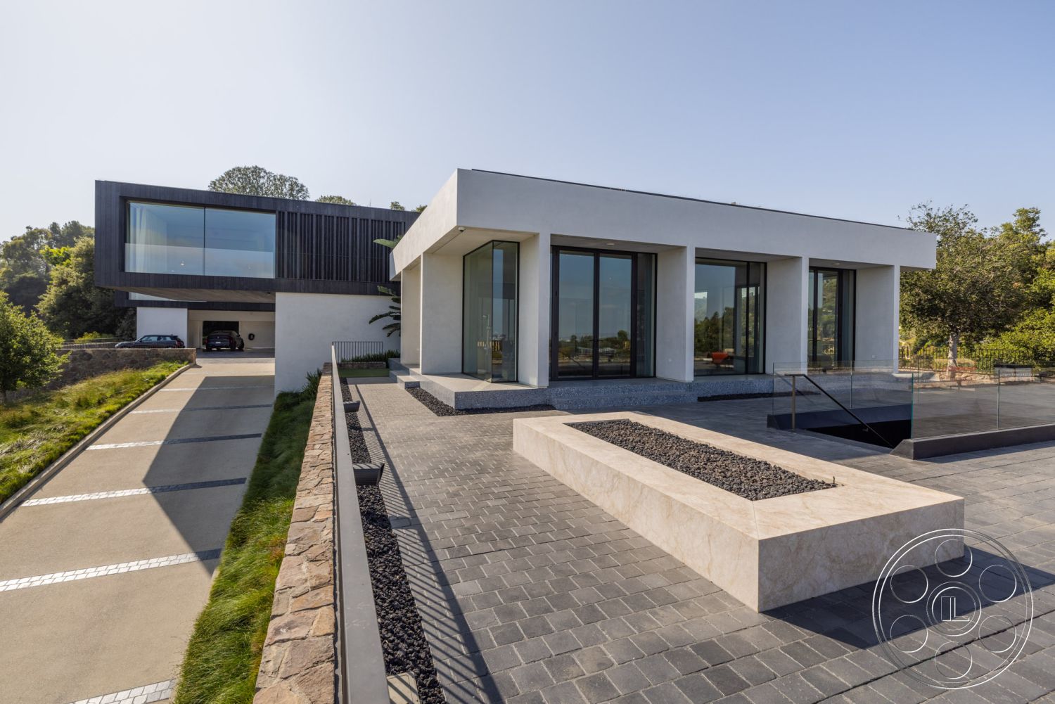 Modern 513 - exterior landscaped garden area, exterior concrete driveway, exterior flat roof design, exterior hillside location, exterior paver patio flooring, interior glass floor-to-ceiling windows, interior white stucco walls, exterior wooden accent wall, exterior geometric planter box, exterior linear fire feature, interior modern minimalist architecture, exterior open floor plan, exterior contrasting materials, interior natural light focused design, interior sleek contemporary design