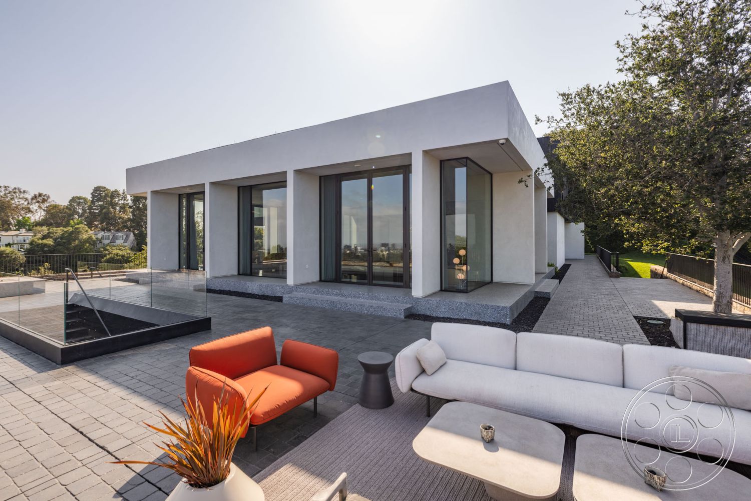 Modern 513 - flat roof, modern outdoor furniture, gravel landscaping, concrete driveway, metal planter, landscaped garden setting, contemporary outdoor seating area, minimalist architectural style, exterior concrete walls, glass floor-to-ceiling windows, urban hillside view, slab concrete patio floor, modern rectangular home shape, paved stone decking, glass railing perimeter, textured plaster wall trim, open patio layout