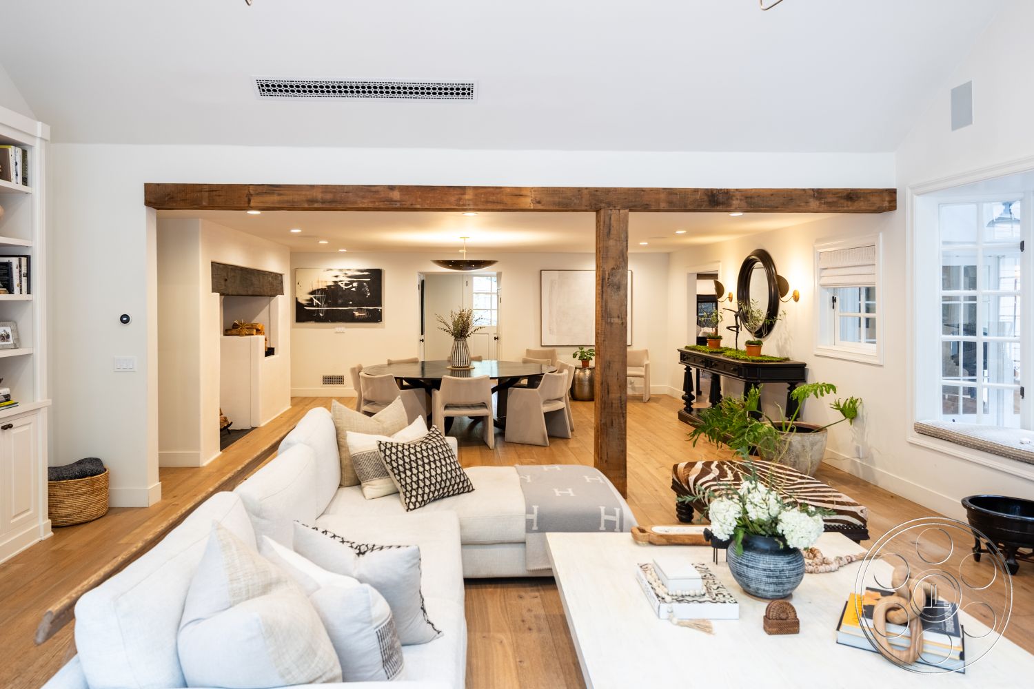 Americana 201 - neutral color palette, open concept layout, large windows for natural light, modern coffee table, natural wood dining table, textured throw pillows, stylish accent chairs, contemporary lighting fixtures, built-in bookshelves, hardwood living room floors, minimalist decor style, white painted walls, decorative plant accents, exposed wood ceiling beam, rectangular dining area, soft upholstery sofa, large mirror reflection, curved dining chairs, welcoming foyer