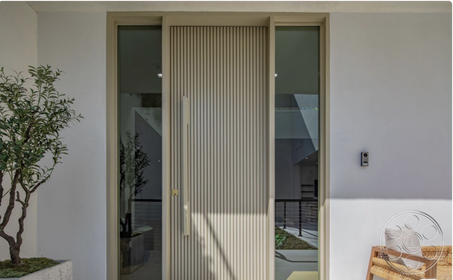 Modern 514 - neutral color palette, open concept design, contemporary seating area, textured plaster wall finish, natural light entryway, exterior entrance with vertical slatted wood door, glass side panel door entry, minimalist modern design, metal door handle, stone planter box with leafy greenery, framed glass entrance, suburban contemporary home, landscaped front area