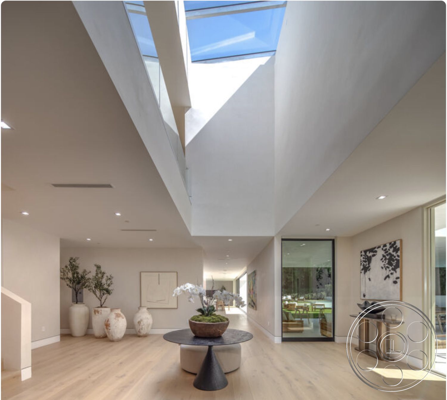 Modern 514 - neutral color palette, glass sliding doors, soft natural light, interior garden view, textured plaster walls, minimalist coffee table, contemporary interior design, vaulted ceiling with skylight, ceramic planter with greenery, artistic decorative elements, light hardwood living room floors, large abstract wall art, modern accent table, bright open concept layout, exposed staircase design, sunlit hallway leading to outdoor area, open space with natural materials